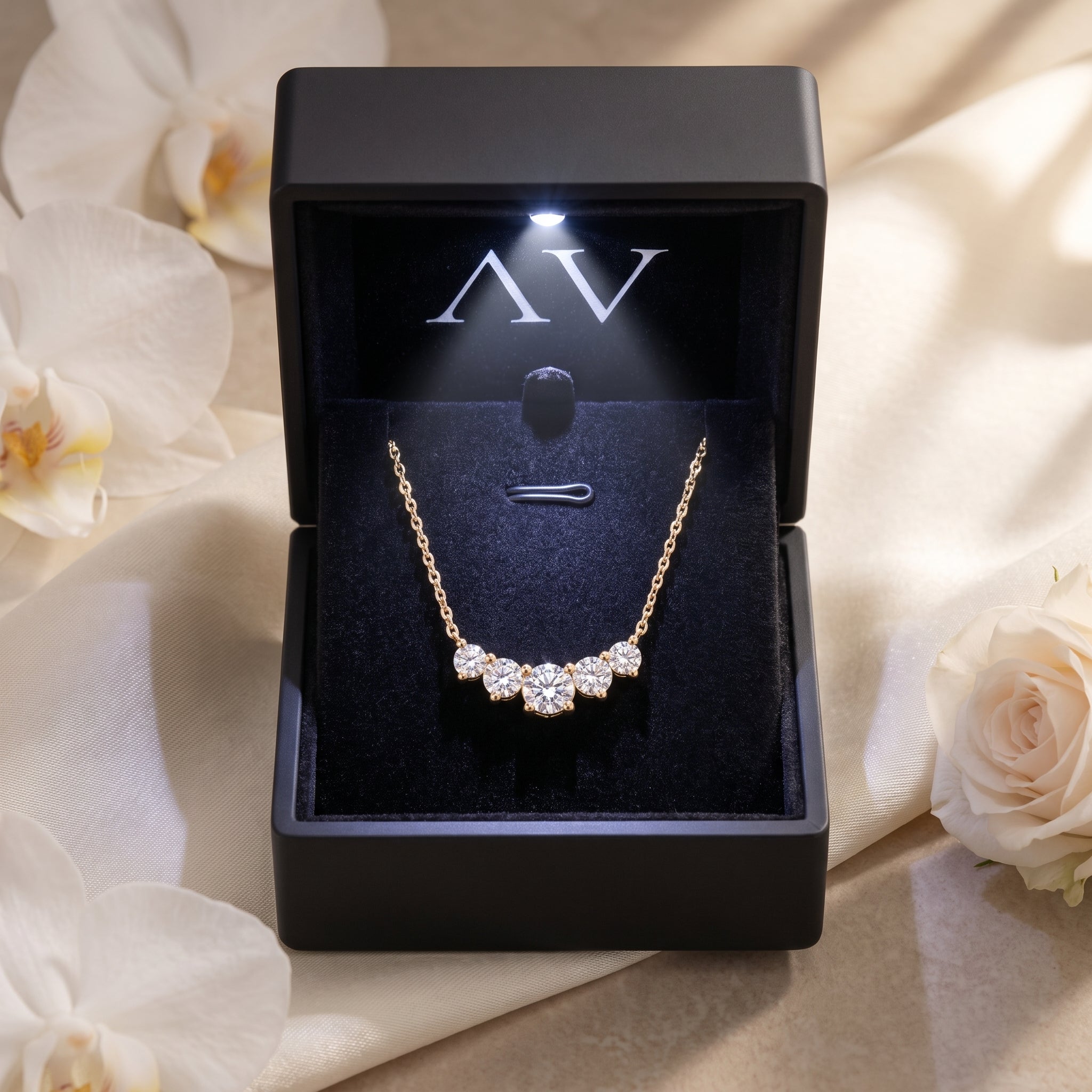 Yellow gold Antonella moissanite necklace presented in a black LED-lit jewelry gift box.