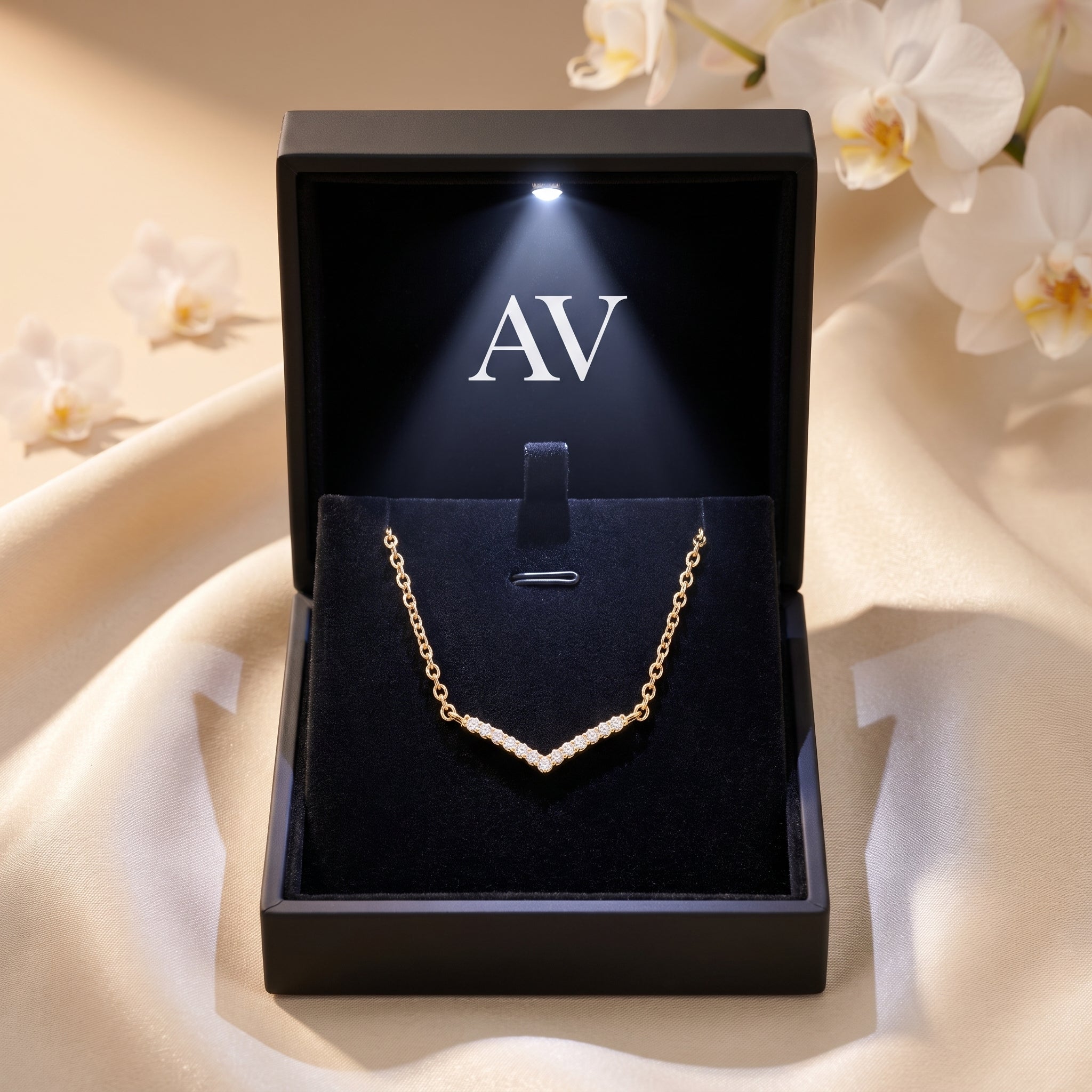 Gold chevron moissanite necklace in a black LED-lit gift box.