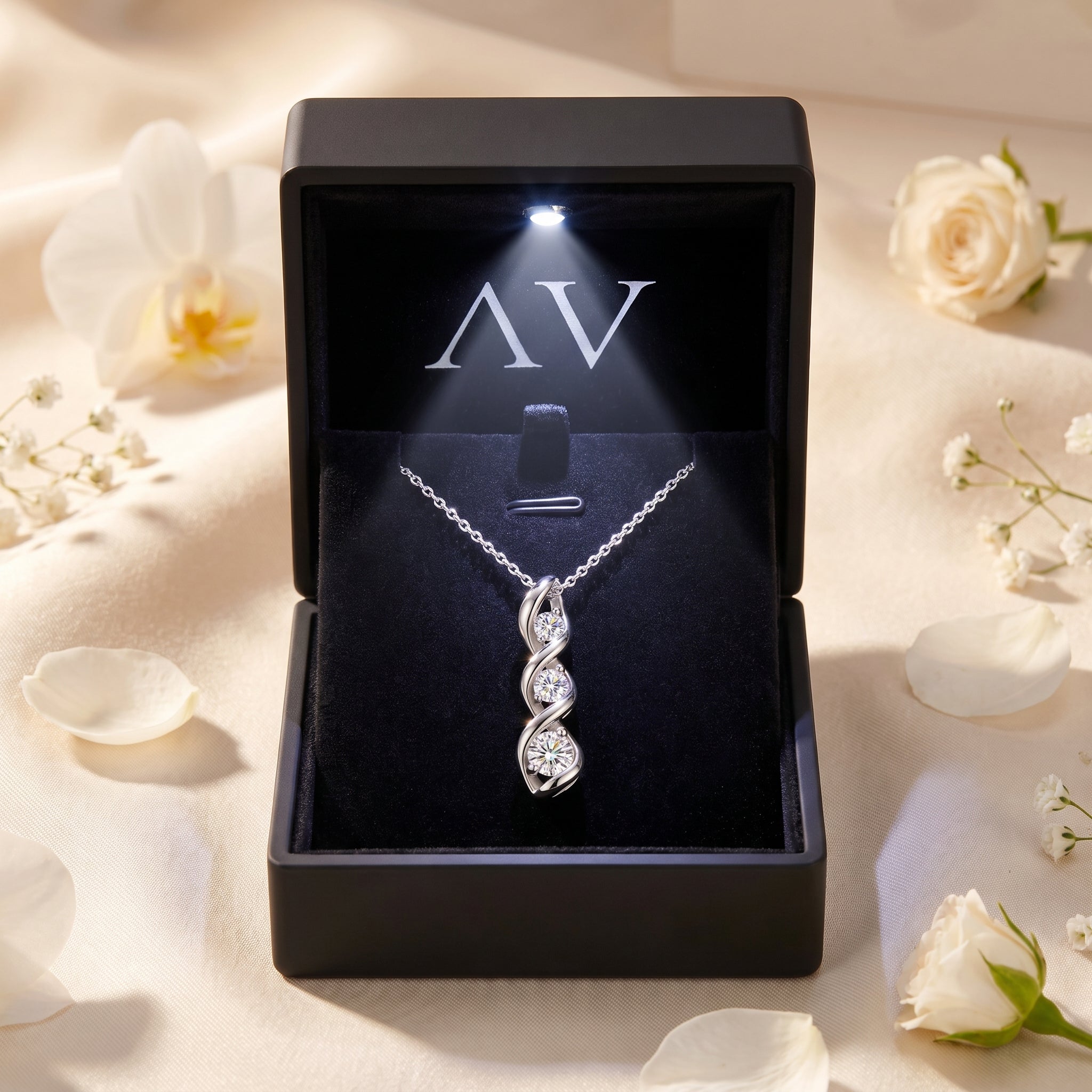 Silver Adrastia moissanite pendant inside a black LED-lit luxury gift box with white floral accents.