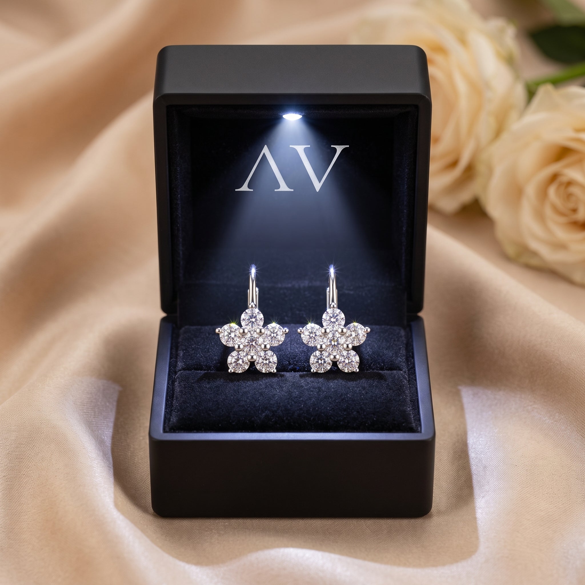 Silver floral moissanite drop earrings in a black LED-lit gift box.