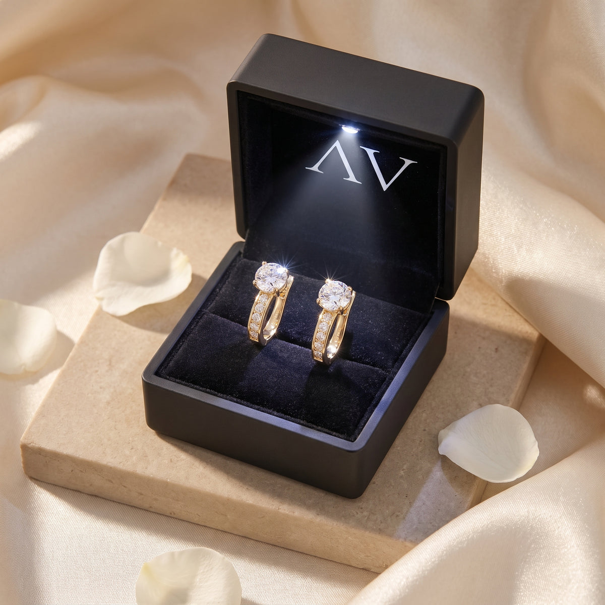 Gold moissanite hoop earrings inside a black lighted jewelry gift box.