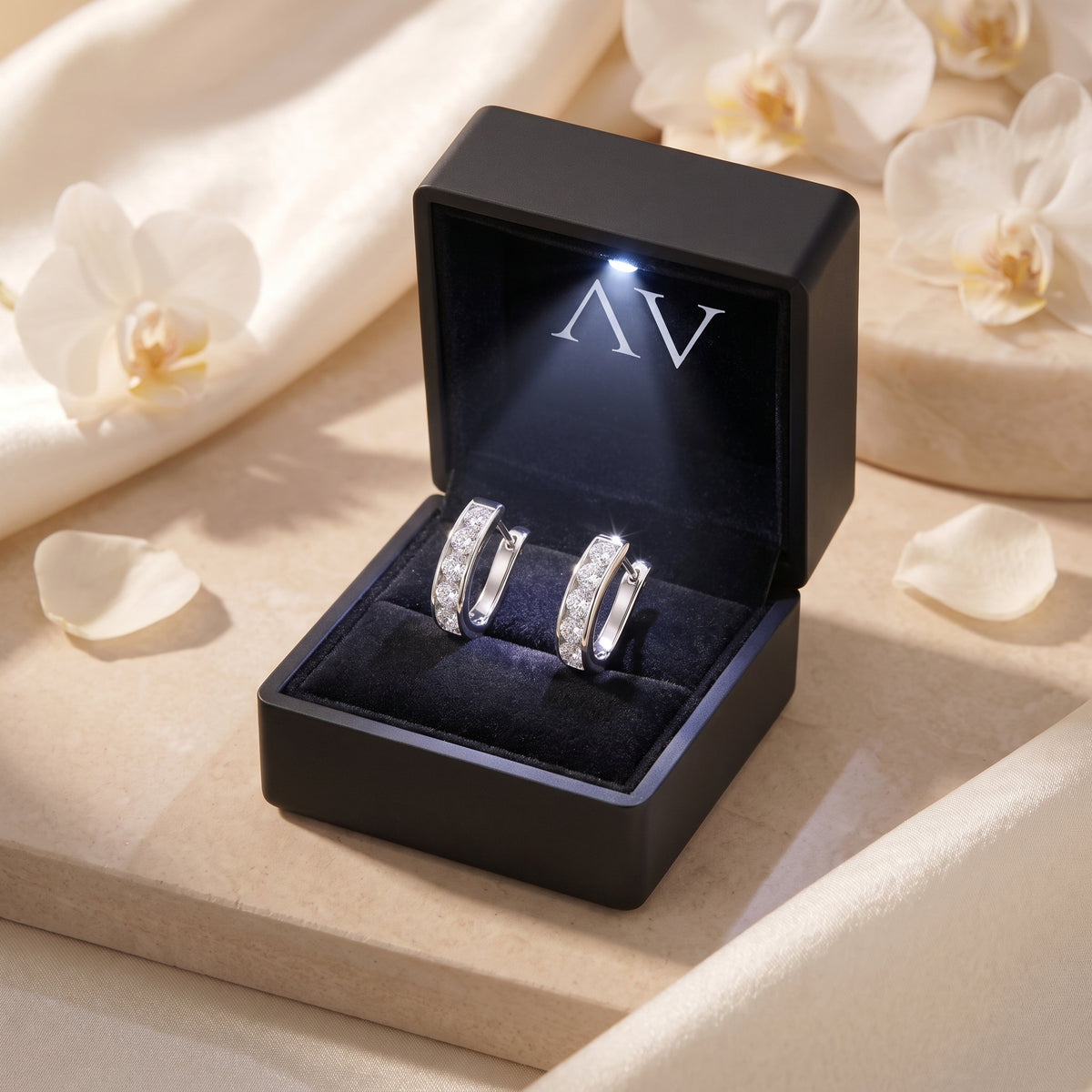 Silver moissanite hoop earrings inside a black LED-lit presentation box.