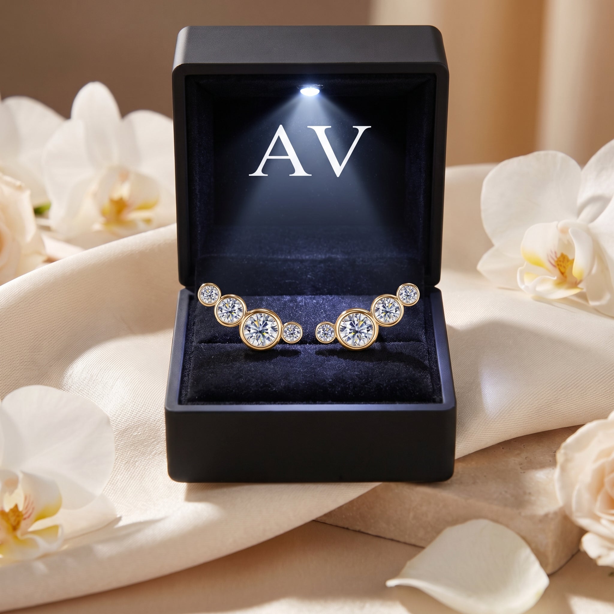 Gold moissanite climber earrings presented in a black LED-lit gift box with white floral background.