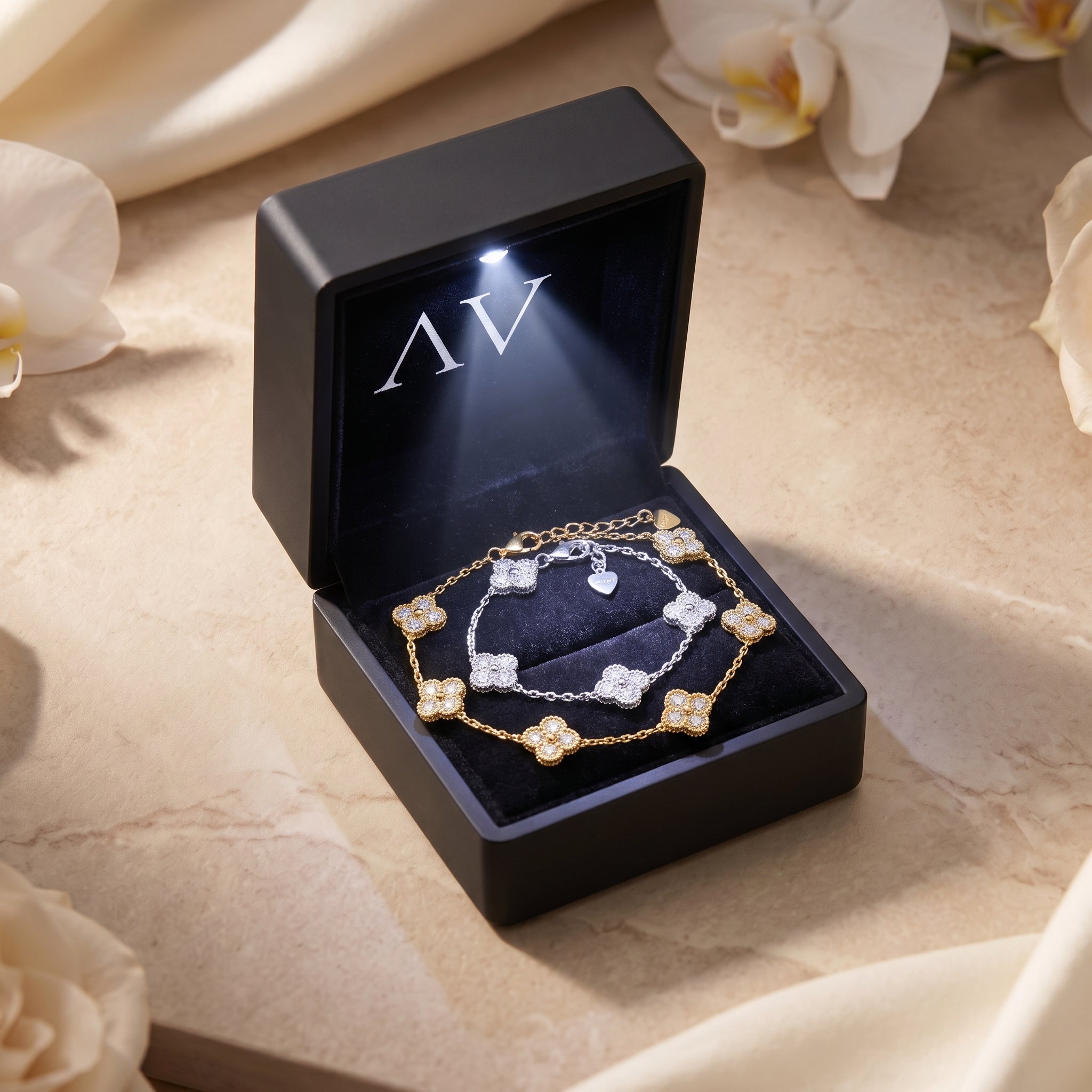 Gold and silver moissanite clover bracelets inside a premium lighted black jewelry gift box.