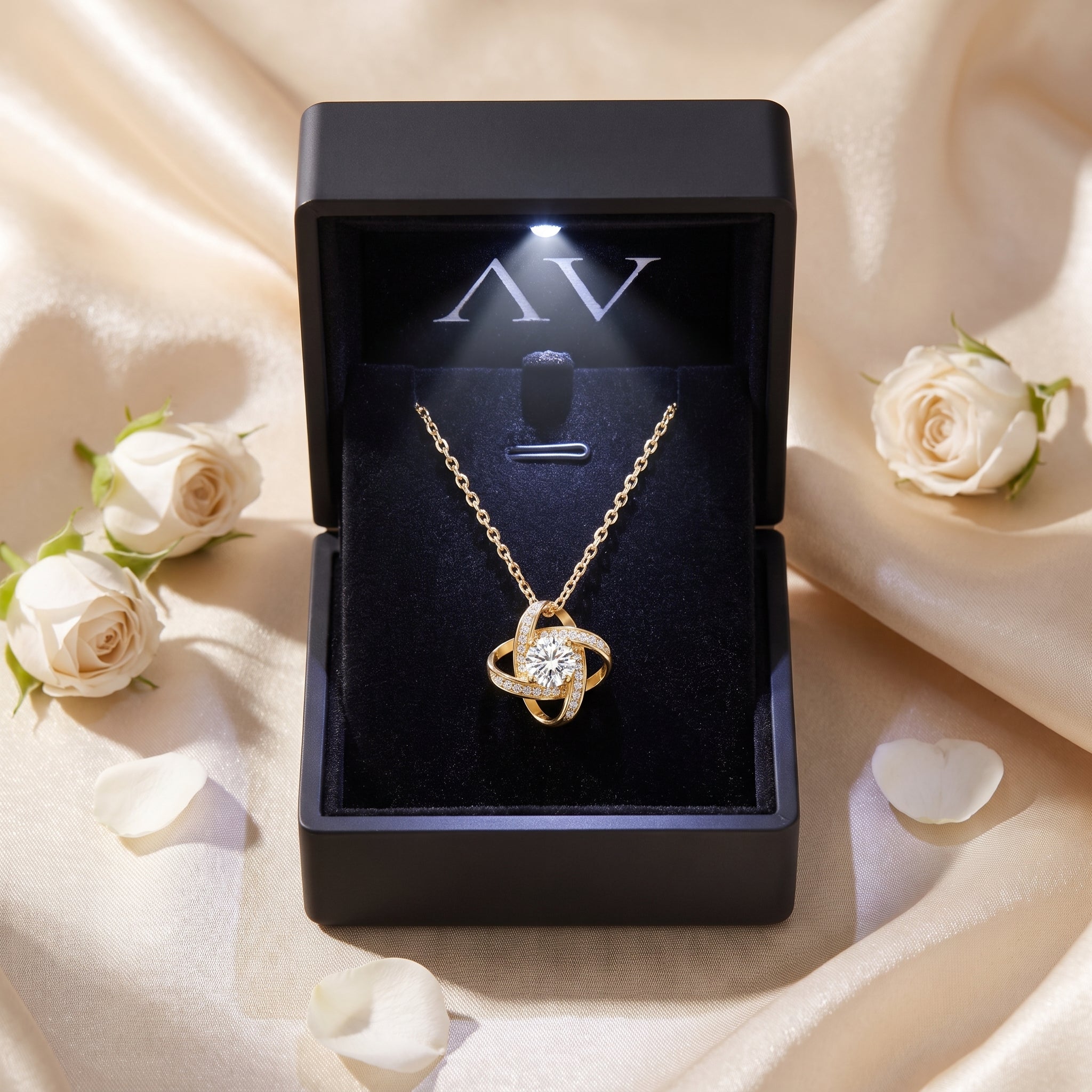 Yellow gold moissanite knot necklace inside a black LED-lit jewelry gift box.