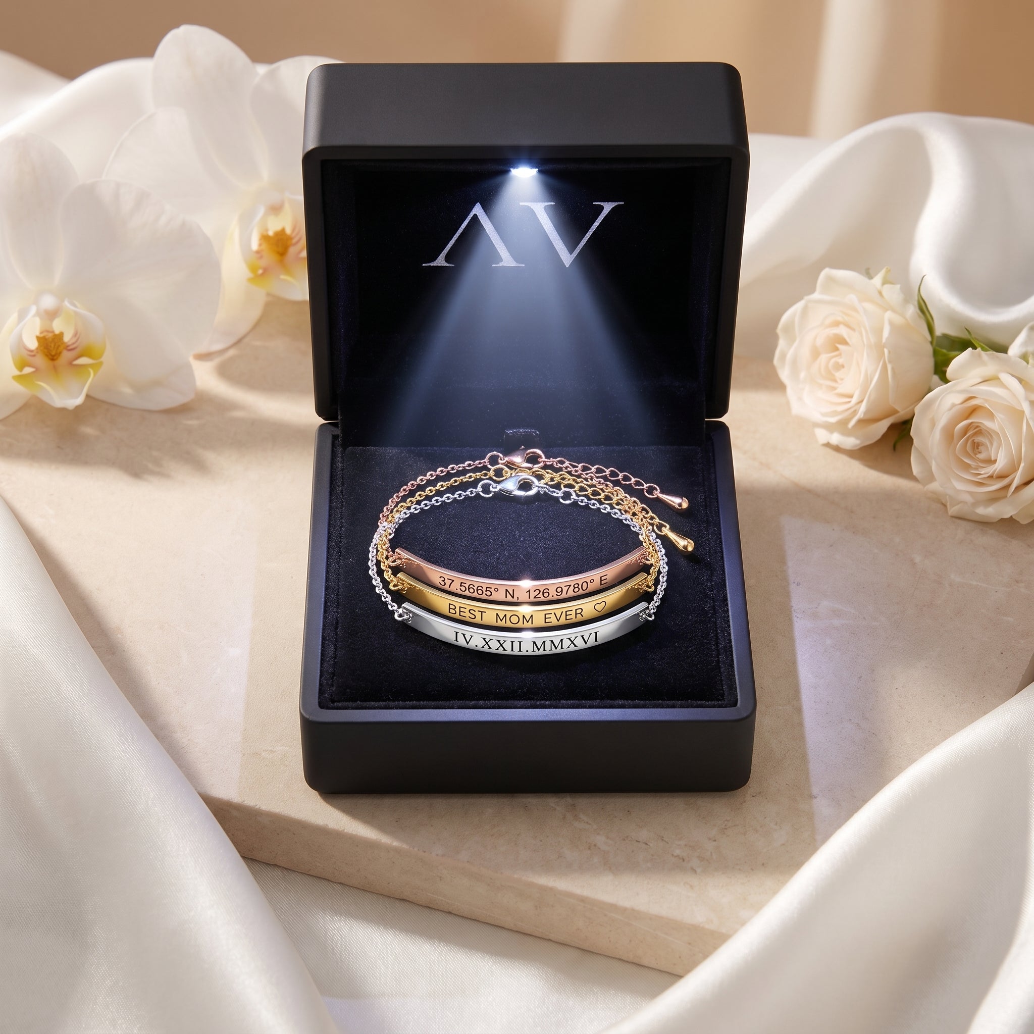 Three personalized Eleanor Bar Bracelets in rose gold, gold, and silver inside a black LED-lit jewelry gift box.
