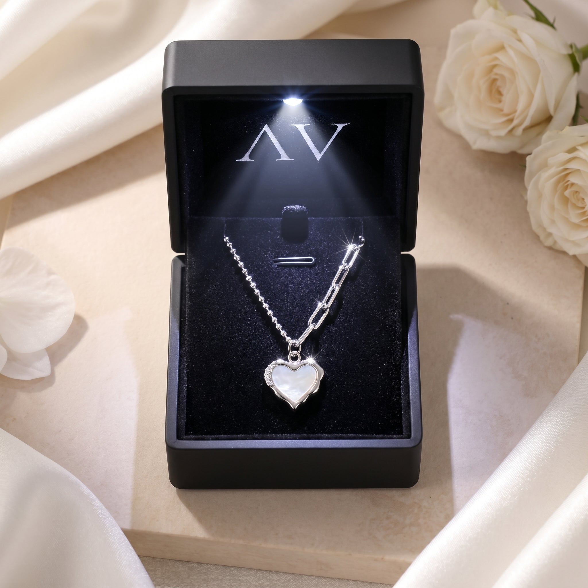 Silver heart opal necklace inside a premium black LED-lit jewelry gift box with white roses.