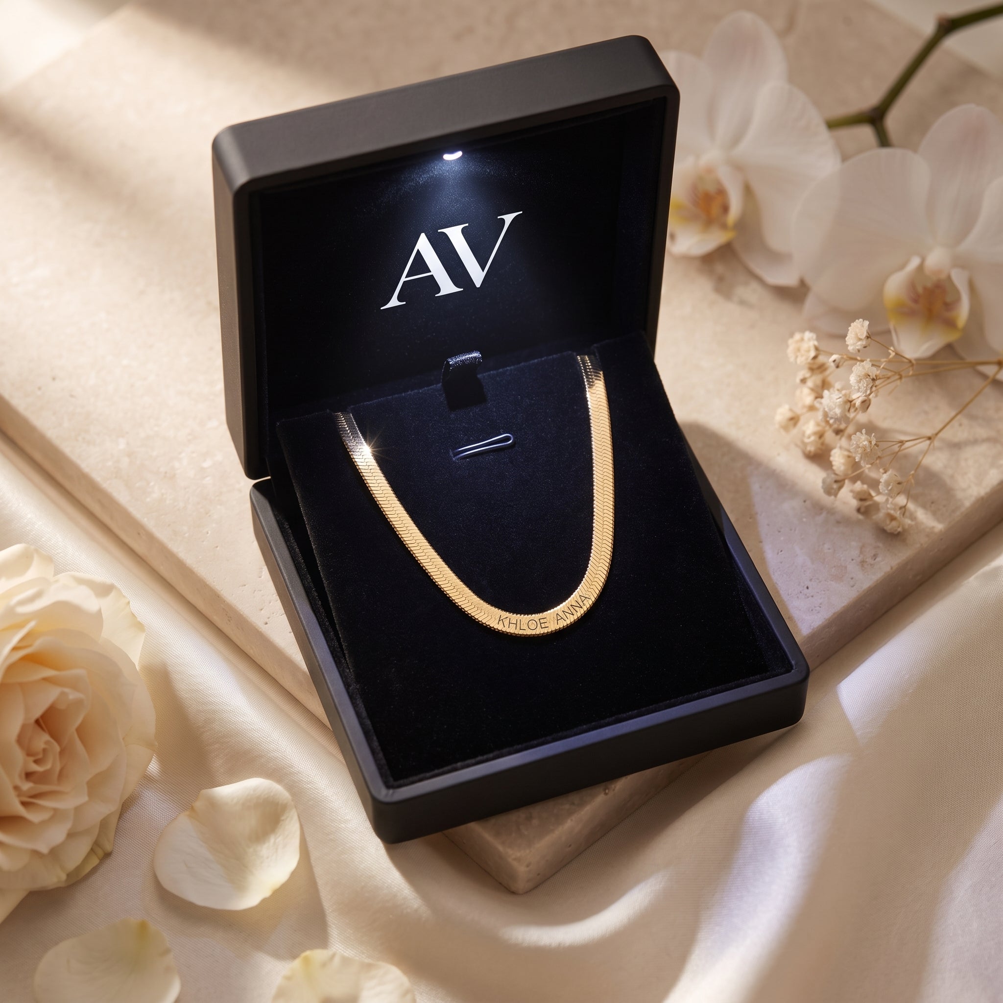 18K gold finish custom name herringbone necklace in a black LED-lit gift box.