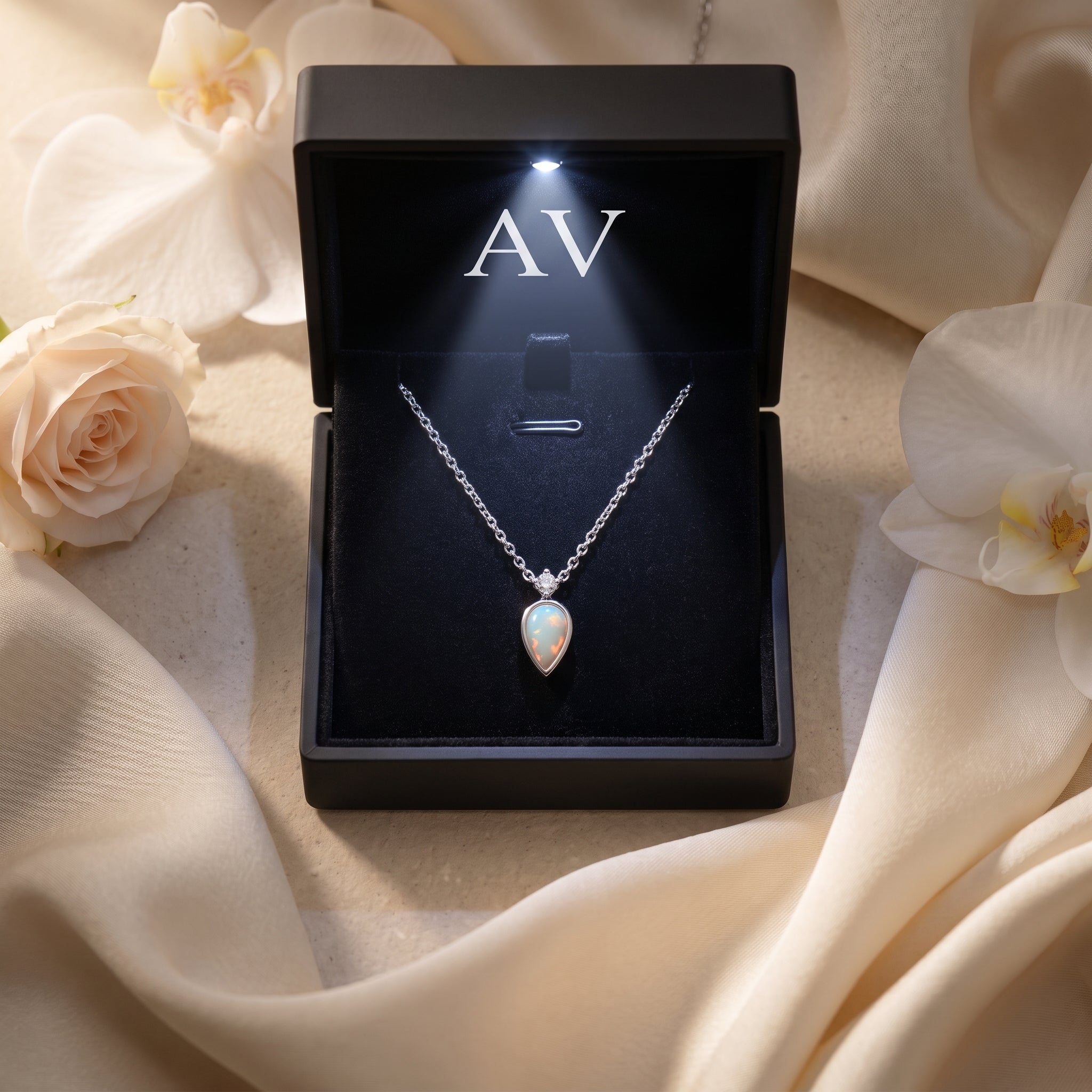 Silver white opal necklace in a black LED-lit gift box with AV branding and floral background.