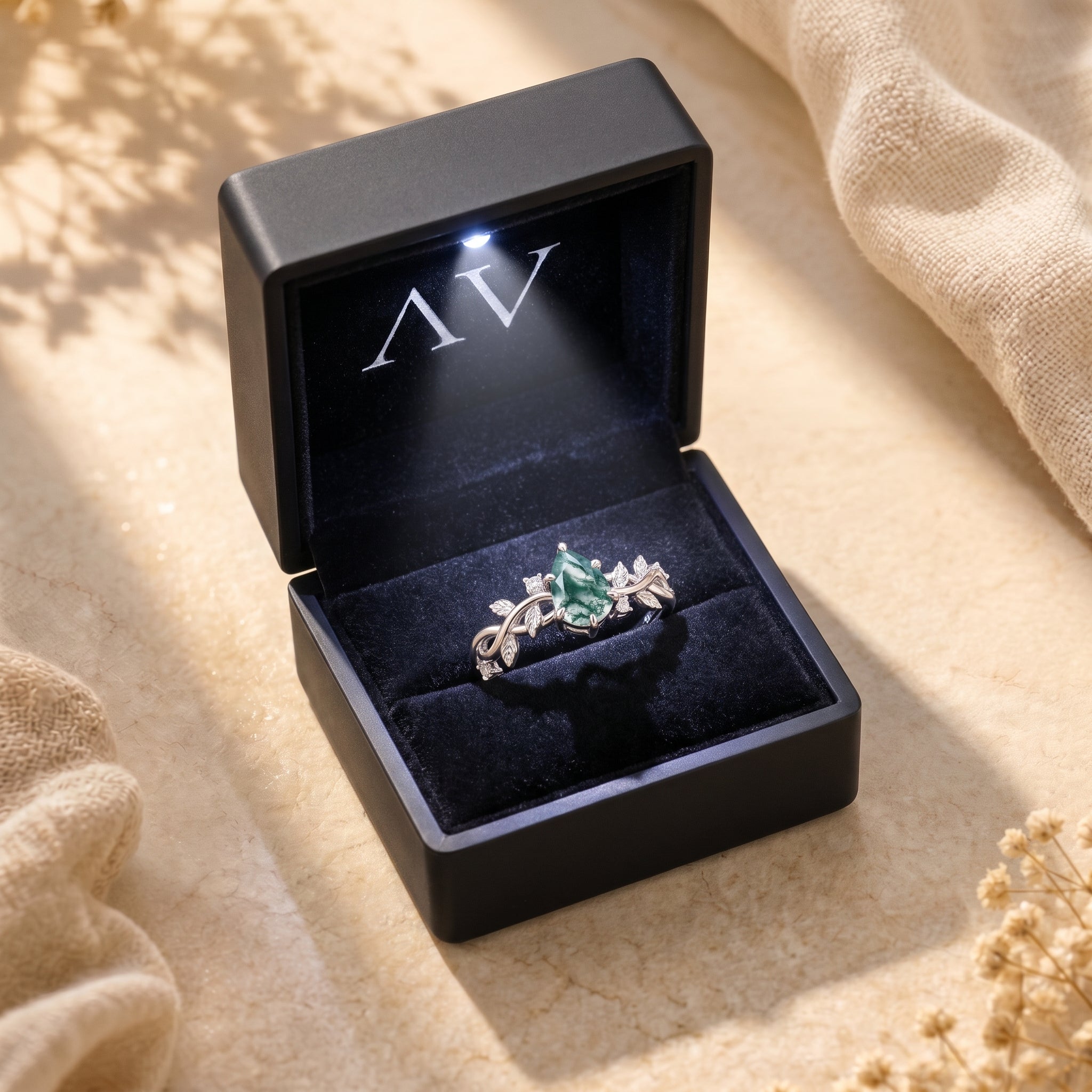 Silver moss agate ring in a lighted black jewelry gift box.