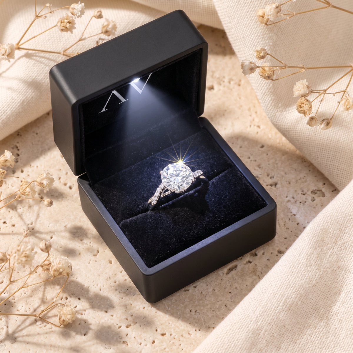 Round moissanite ring in silver presented in a black LED-lit jewelry gift box.