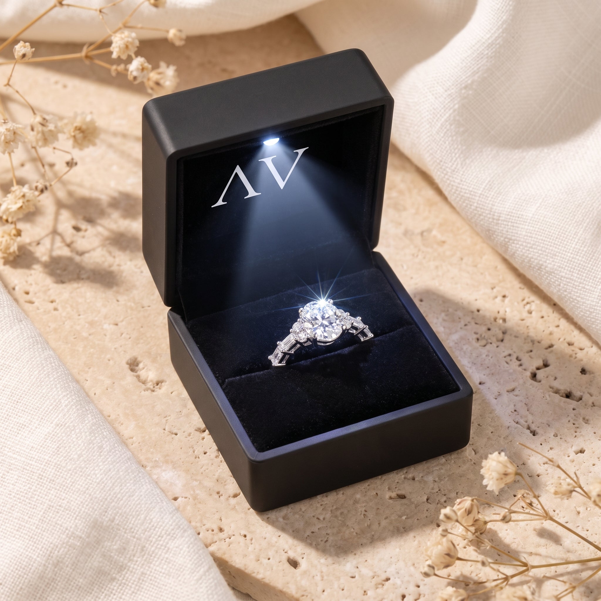 Silver oval moissanite promise ring displayed inside a black LED-lit jewelry gift box.