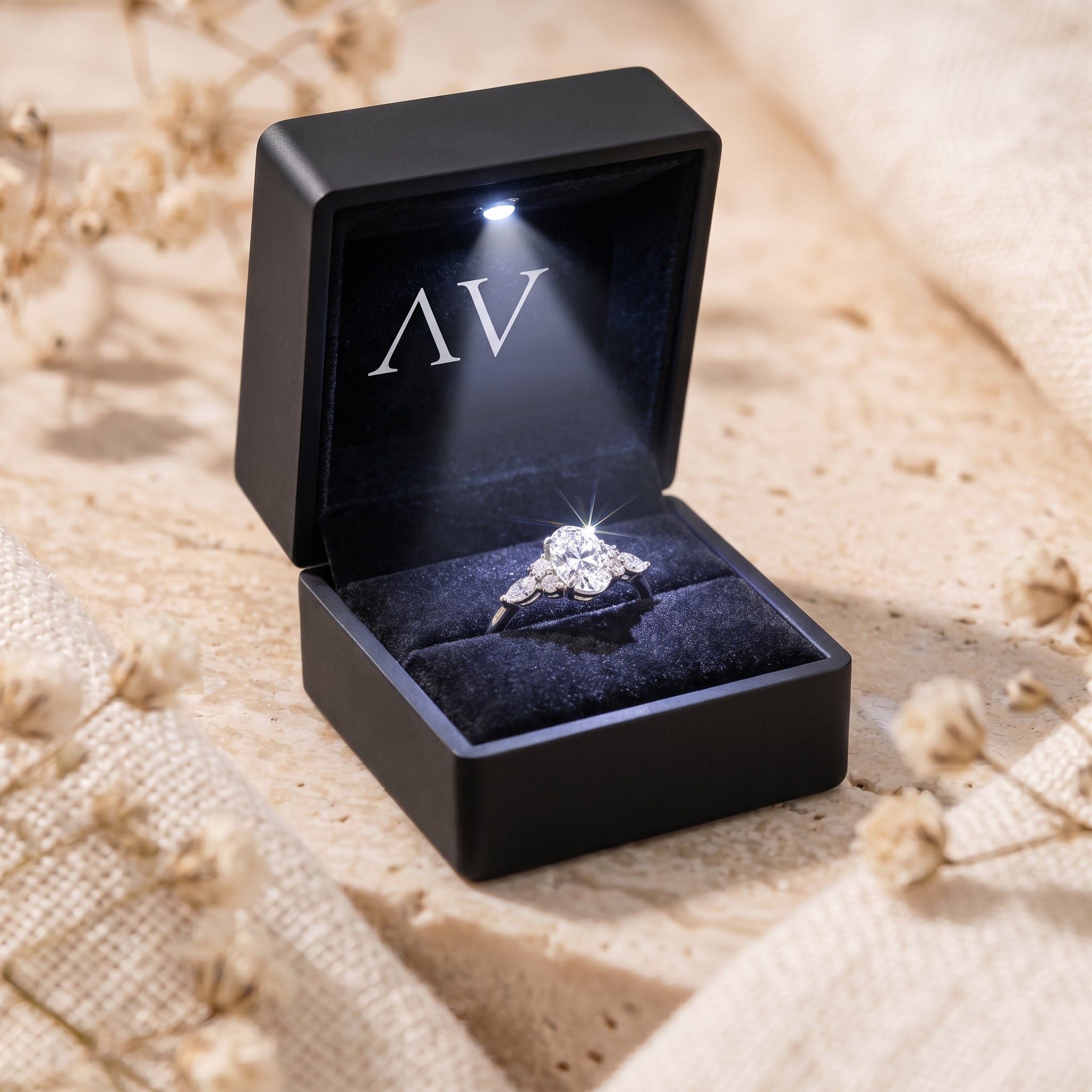 Oval moissanite ring inside a black LED-lit jewelry presentation box.