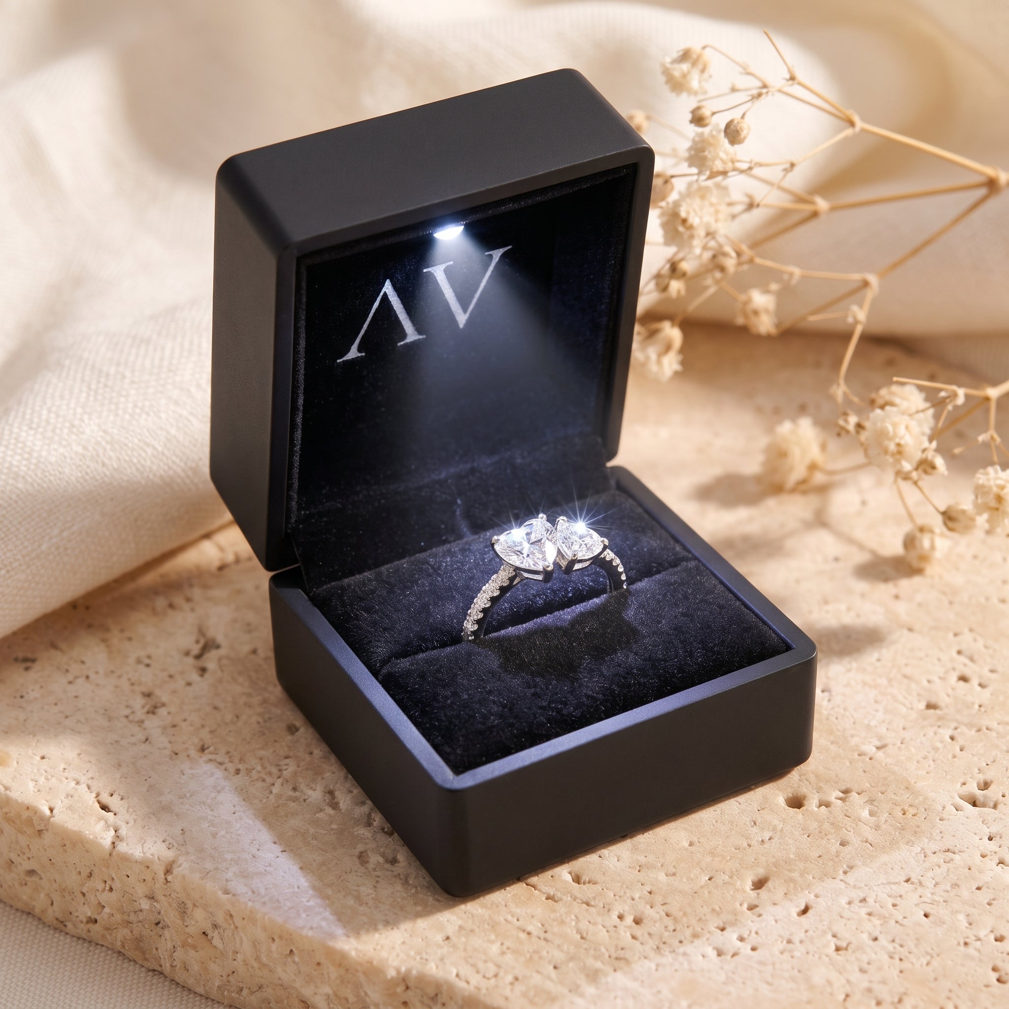 Silver heart-cut moissanite ring inside a black illuminated LED gift box.
