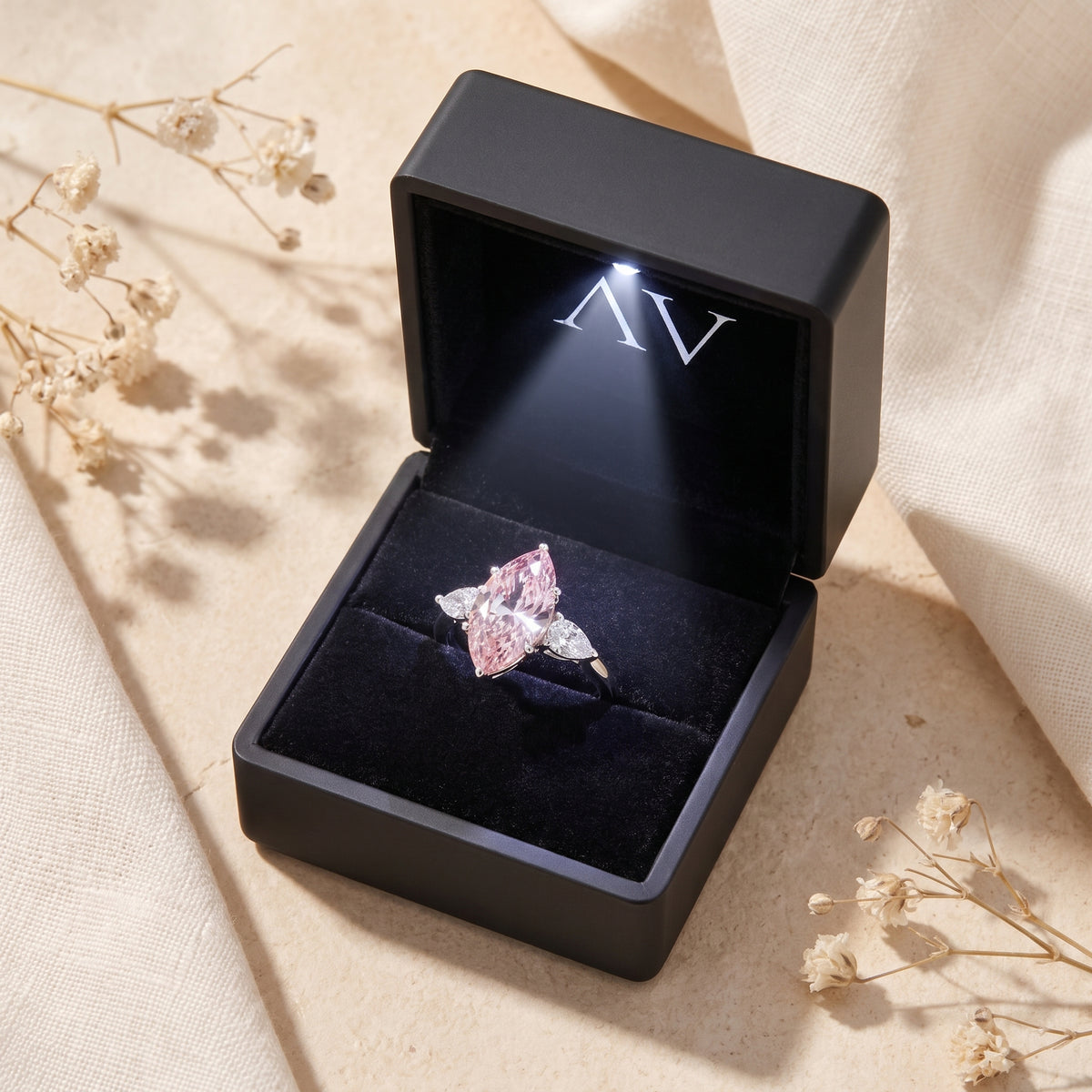 Marquise pink moissanite silver ring inside a black lighted presentation box.