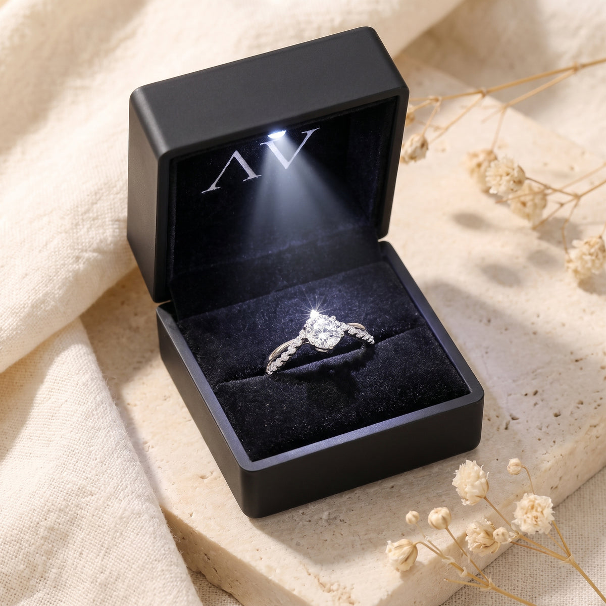 Silver Caladienne round moissanite crown ring inside a black illuminated gift box with a built-in LED light.