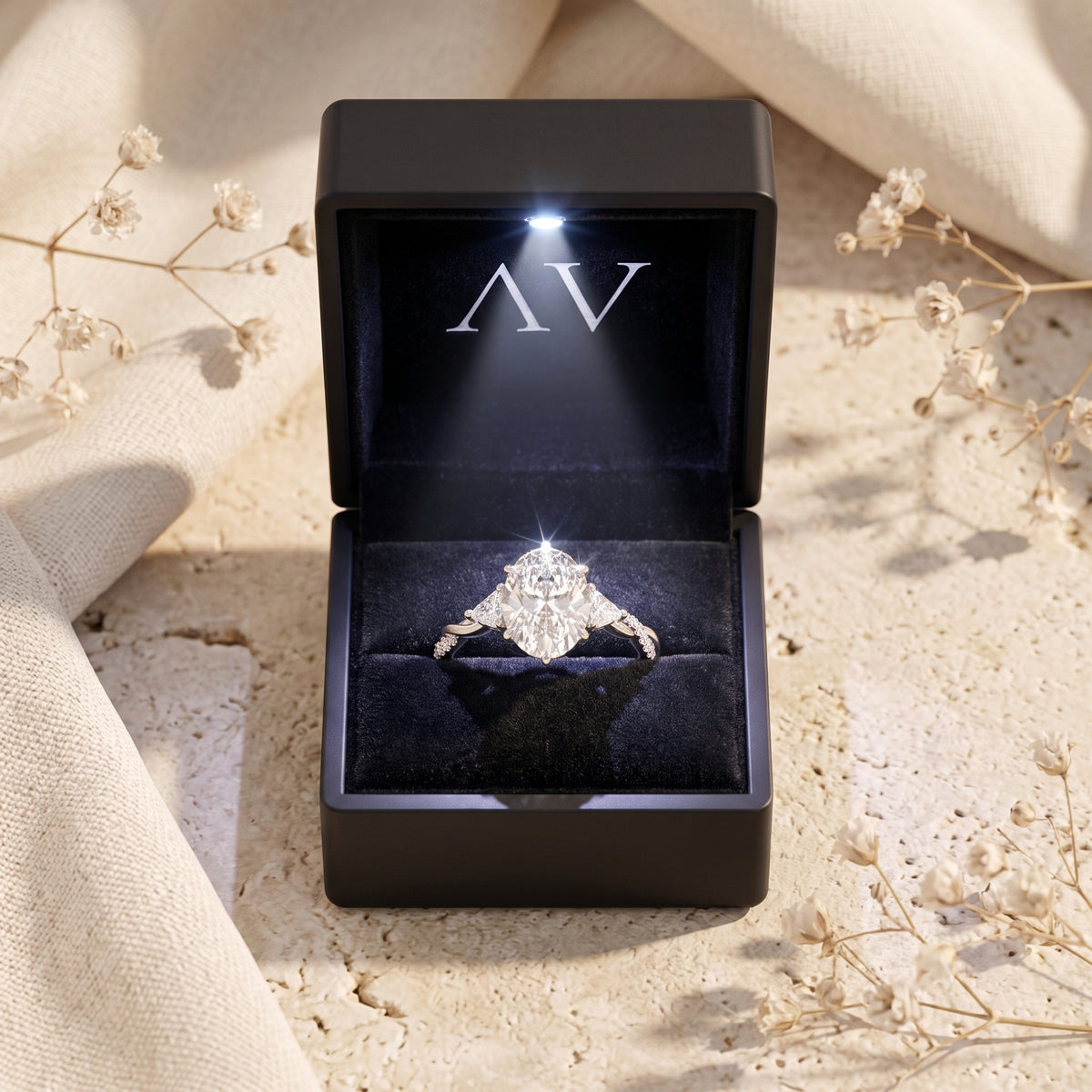 Oval moissanite ring in solid gold inside a black LED-lighted jewelry presentation box.