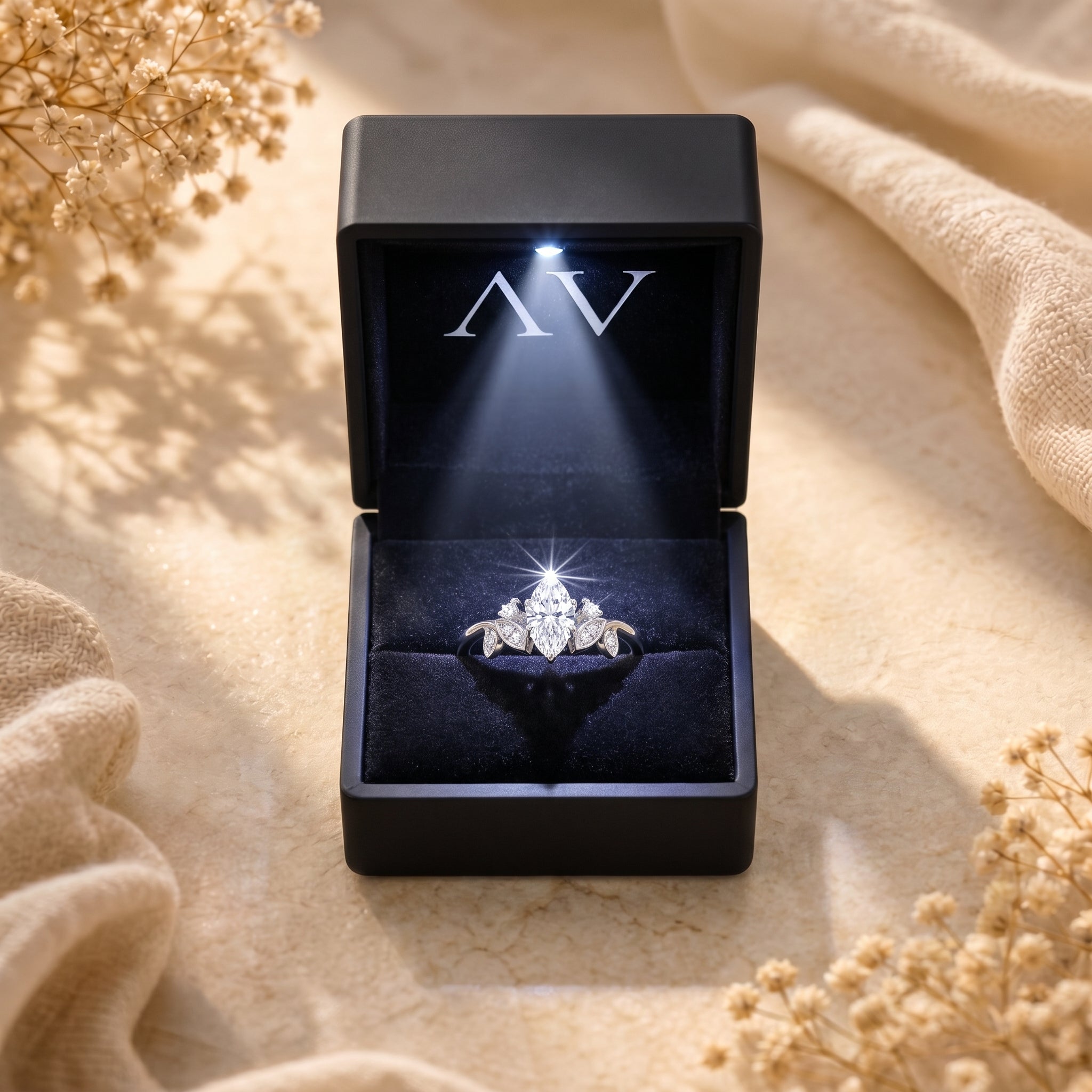 Marquise moissanite silver ring inside a black LED-lighted gift box.