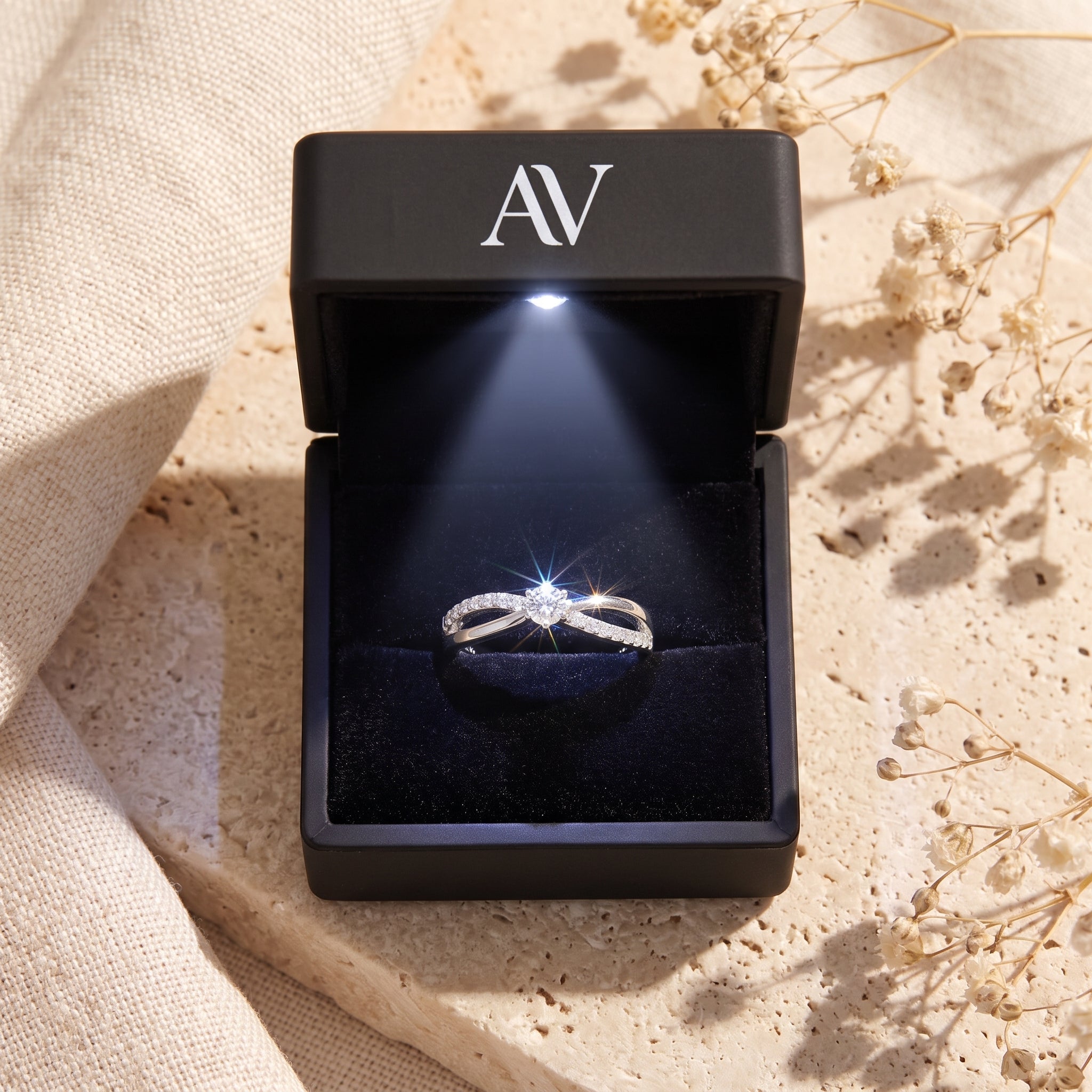 Silver moissanite promise ring in a black LED-lit jewelry box.