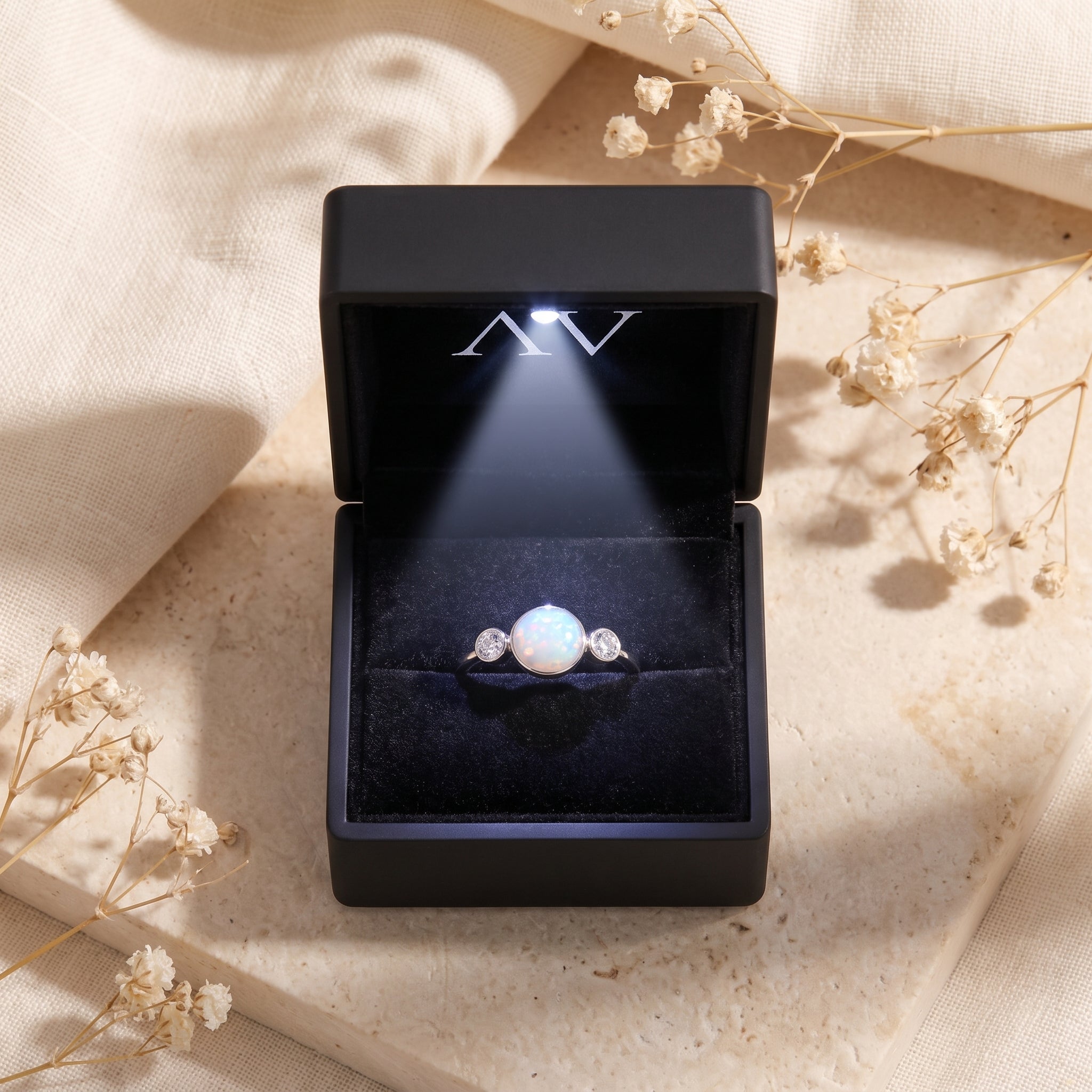 Sterling silver white opal ring inside a black LED-lighted jewelry box.