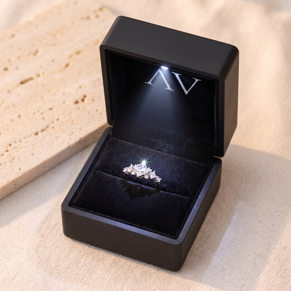 Silver princess-cut CZ promise ring inside a black LED-lit jewelry presentation box.