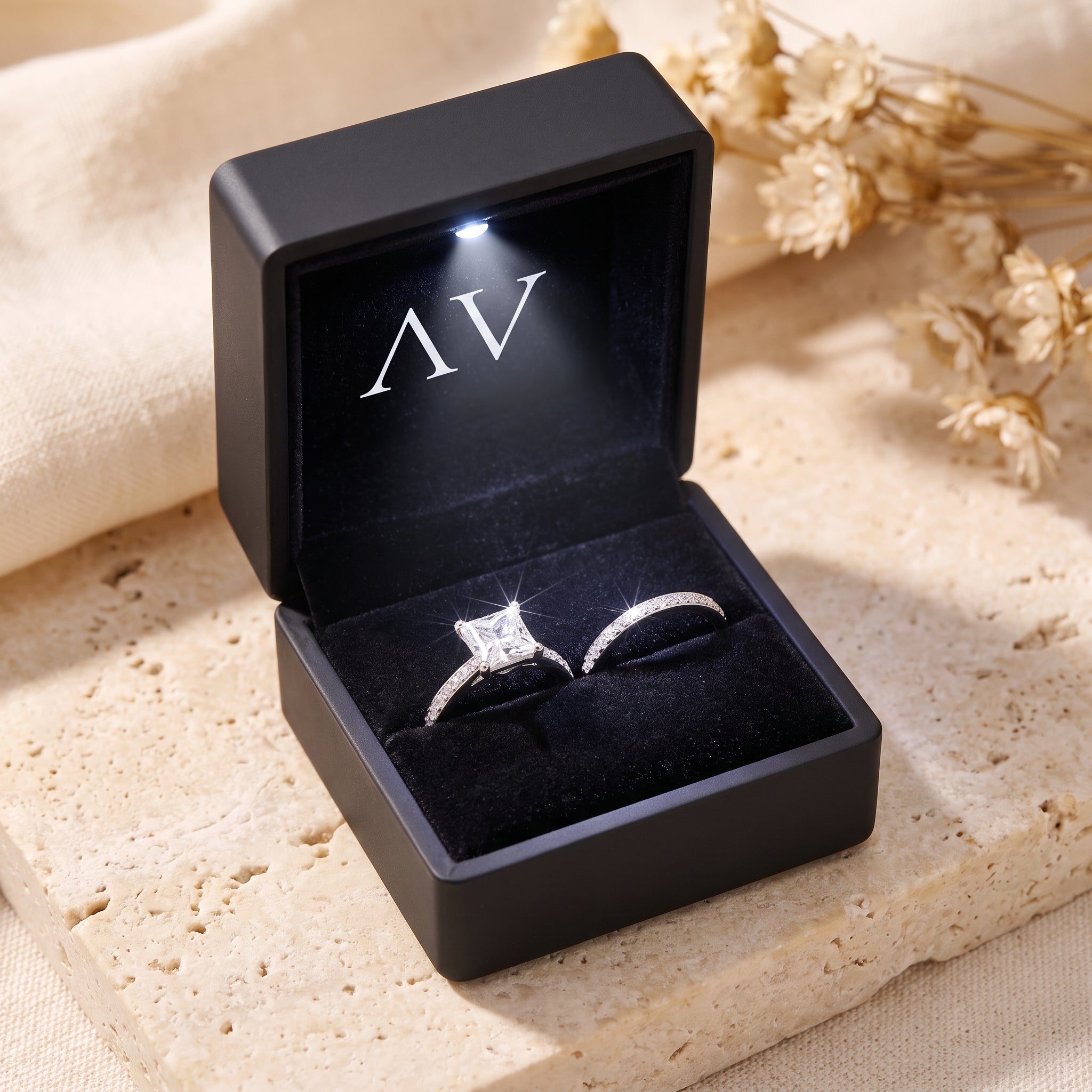 Alaricia sterling silver ring set with square-cut simulated diamond in a black LED-lit jewelry presentation box.
