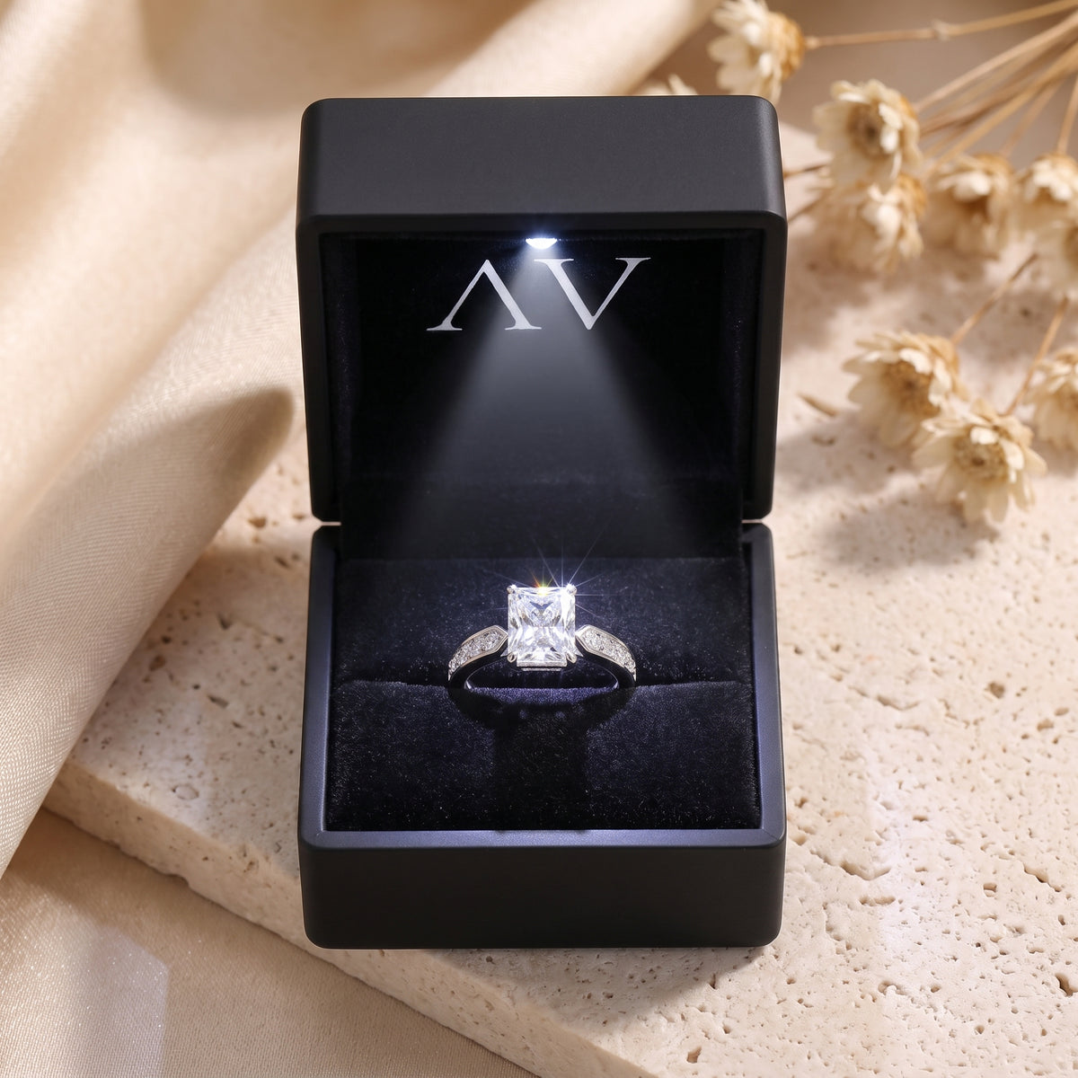 Radiant-cut simulated diamond sterling silver ring presented in a black LED-lit jewelry box.