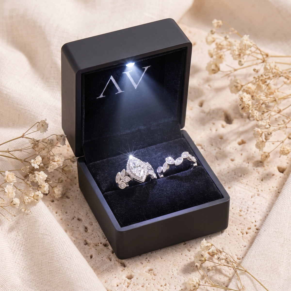 Marquise simulated diamond promise ring set inside a lighted black jewelry box.