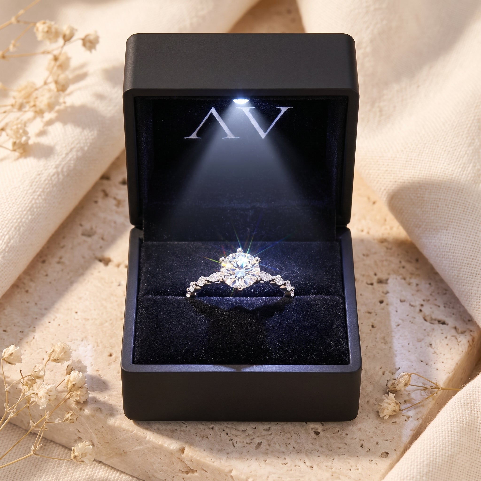 Belise sterling silver ring with a round-cut stone inside a black lighted presentation box.