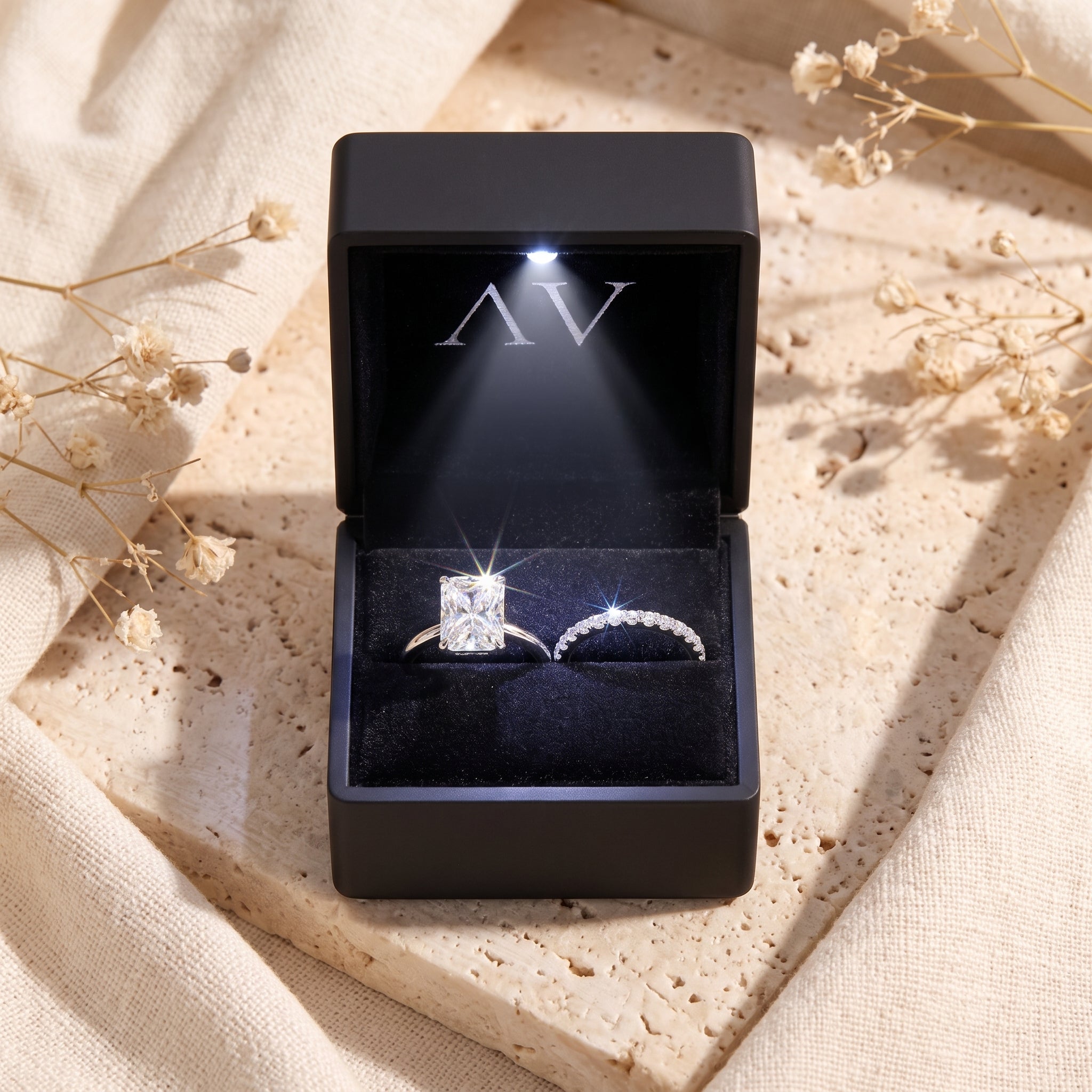 Emerald-cut simulated diamond ring set in a black LED-lit presentation box.