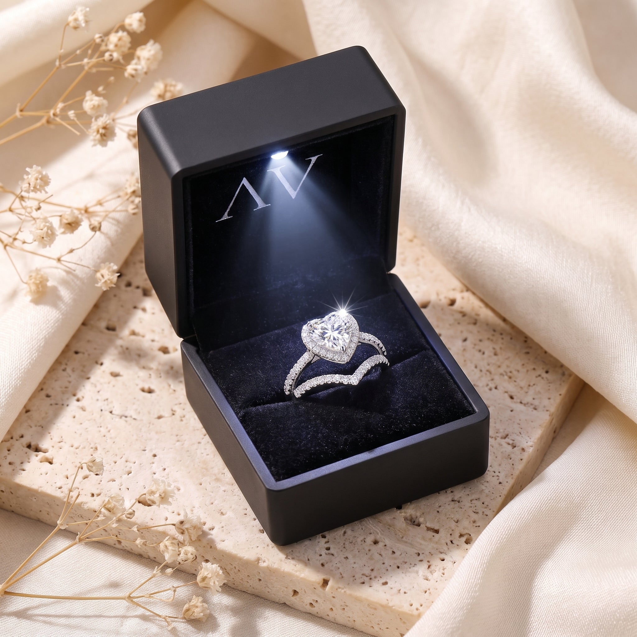 Silver heart halo ring set inside a black LED-lit jewelry box.