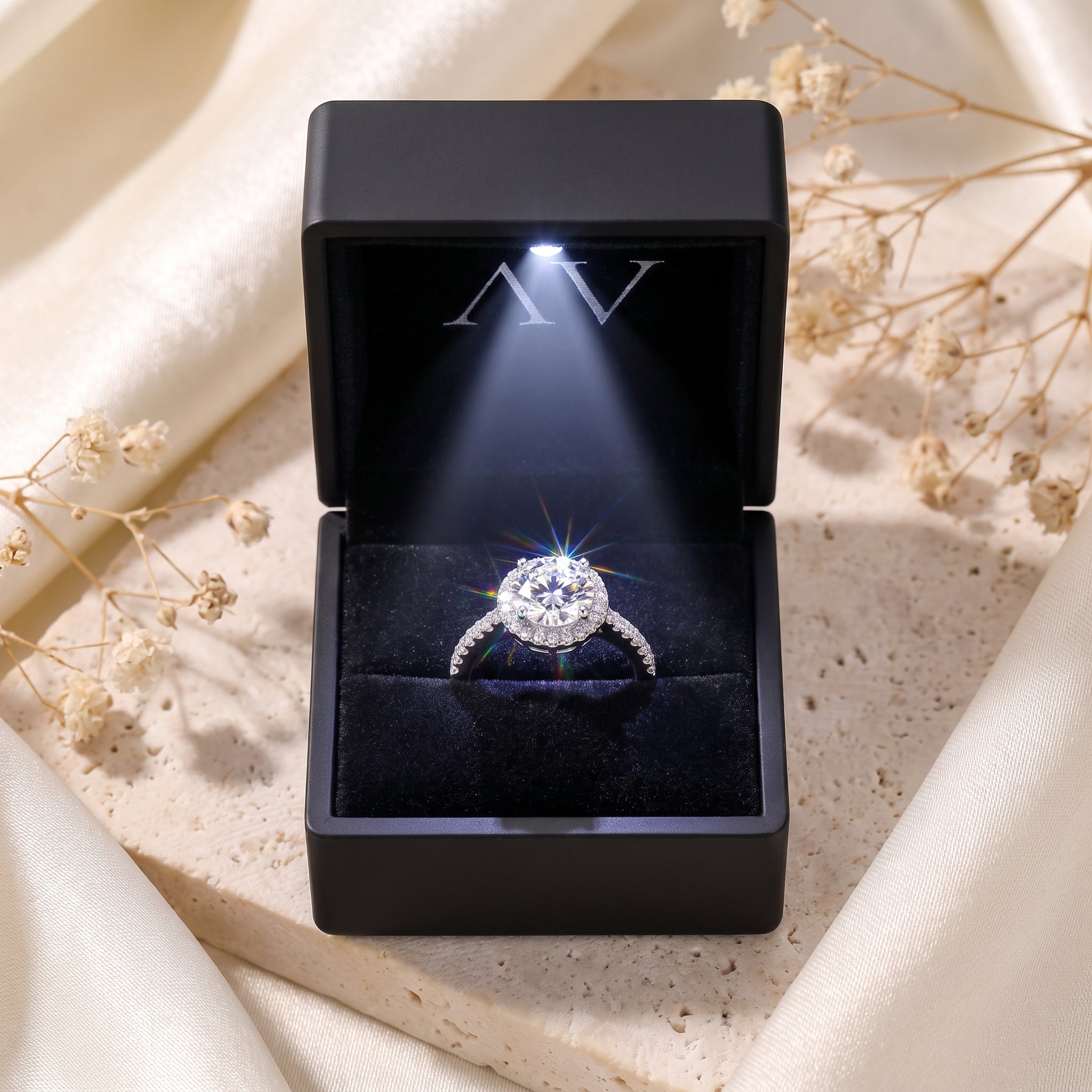 Sterling silver round-cut simulated diamond halo ring inside a black lighted jewelry presentation box.