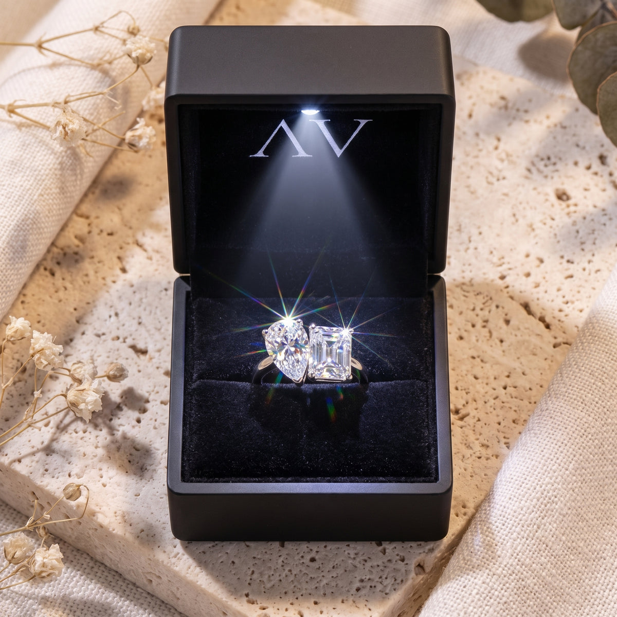 Silver Toi et Moi ring with simulated diamonds in a black LED-lit presentation box.
