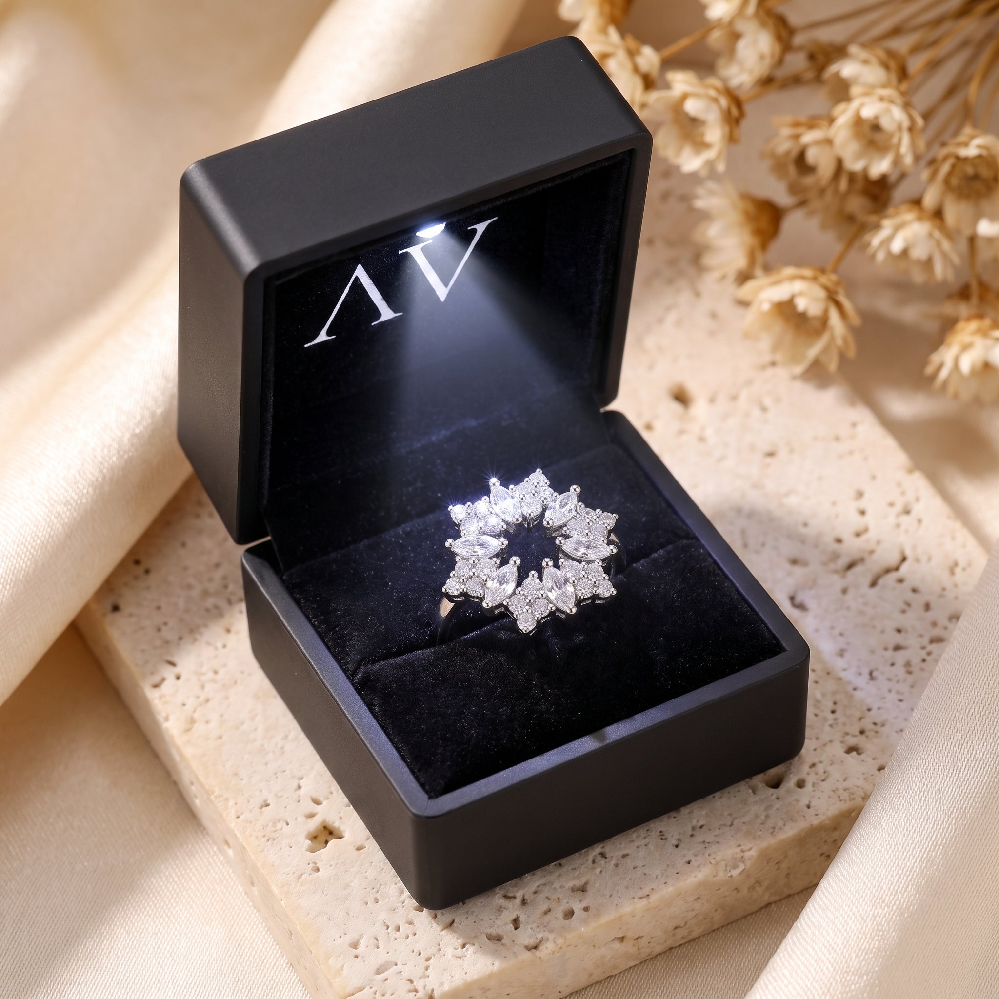 Stellaire S925 sterling silver starburst ring inside an illuminated black velvet jewelry gift box.