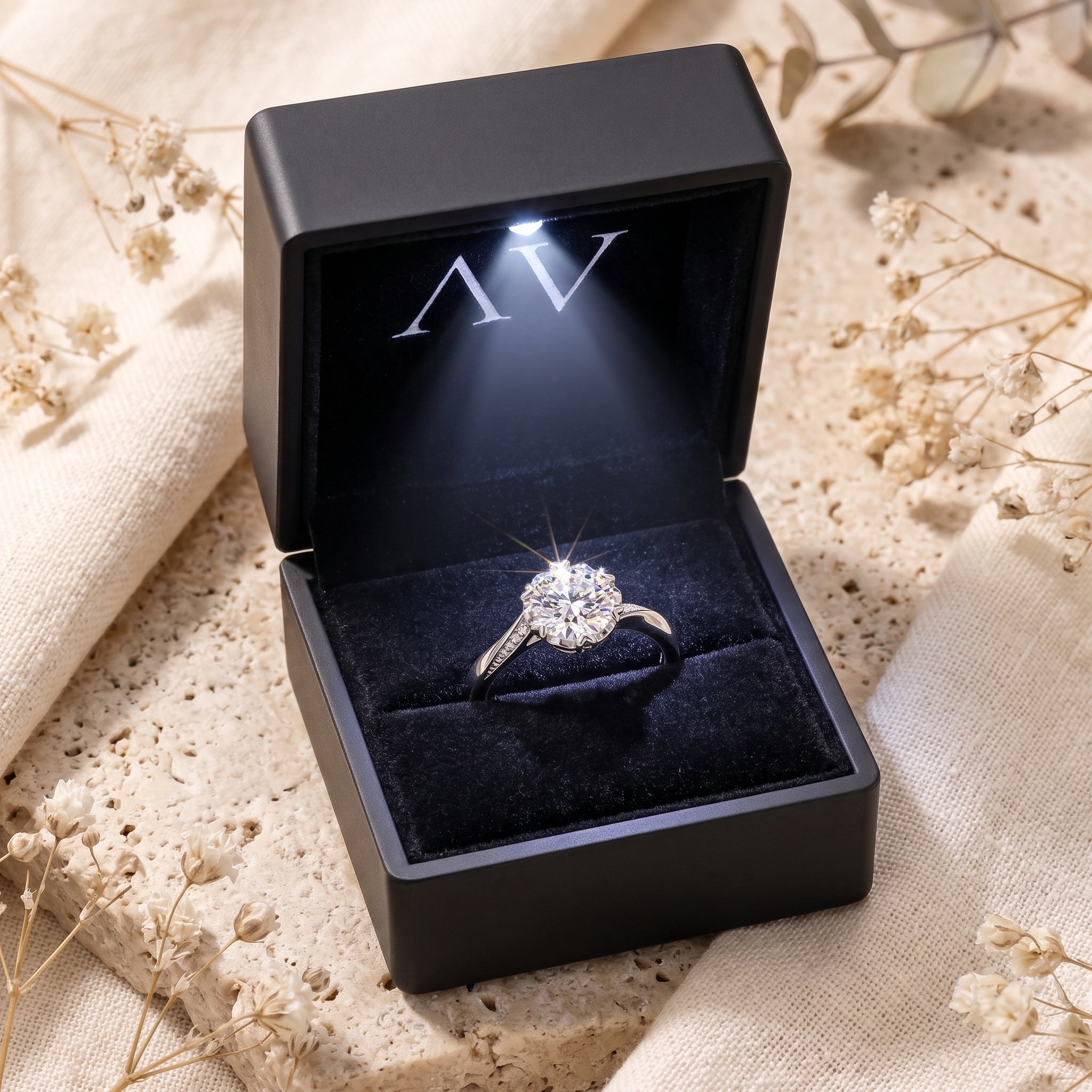 Round cut simulated diamond ring in a black lighted gift box.