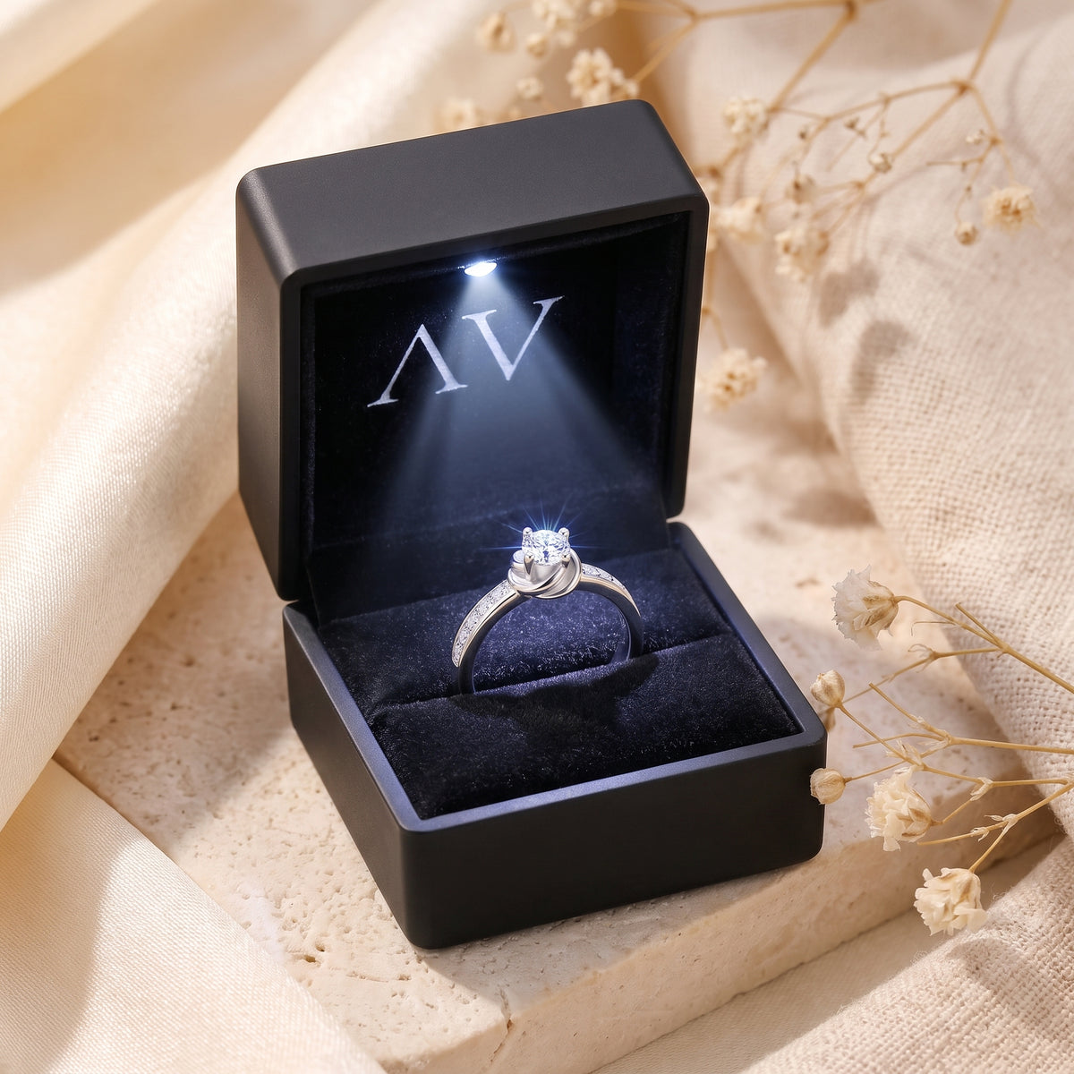 Silver Melisande ring with a round-cut simulated diamond in a black LED-lit jewelry presentation box.