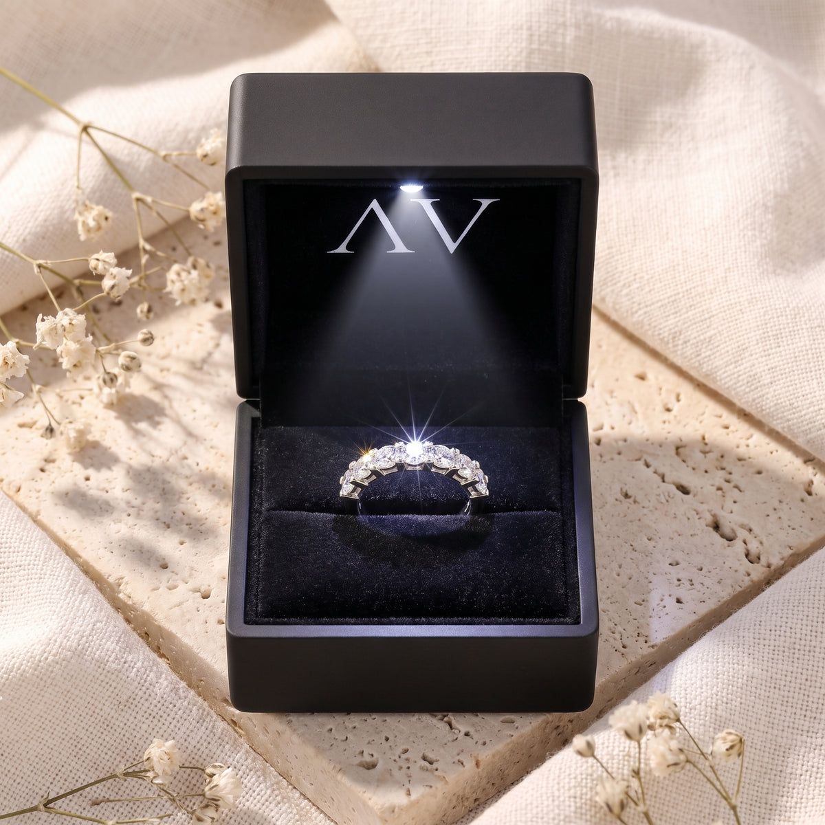 Silver Evadienne eternity ring with sparkling simulated diamonds inside a black lighted jewelry presentation box.