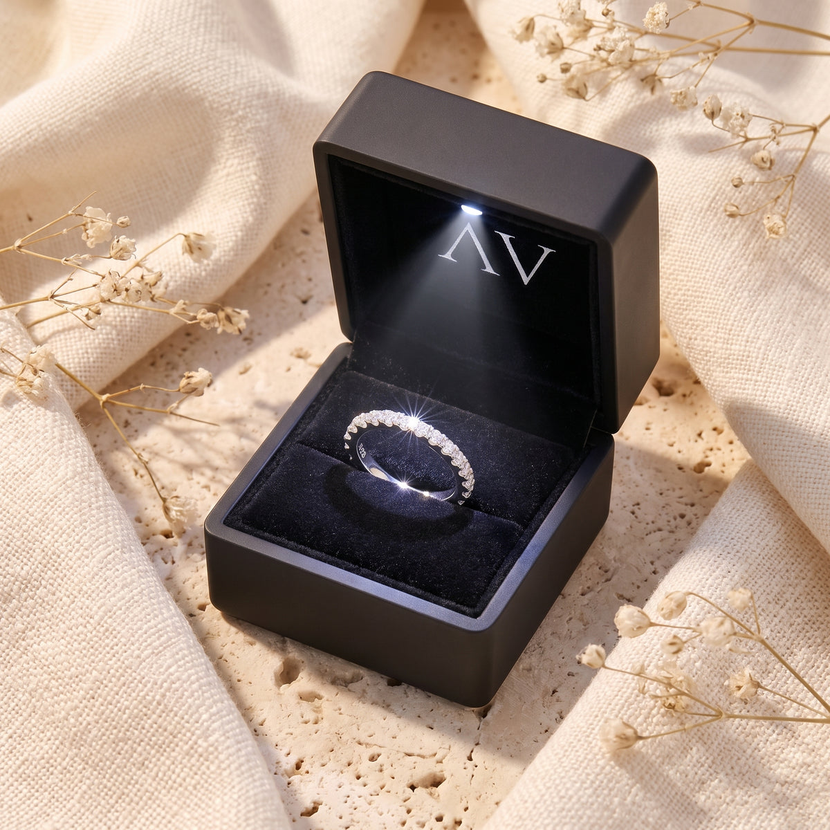 The Fleuriana silver wave ring with simulated diamonds in a black LED-lit jewelry box with branded logo.