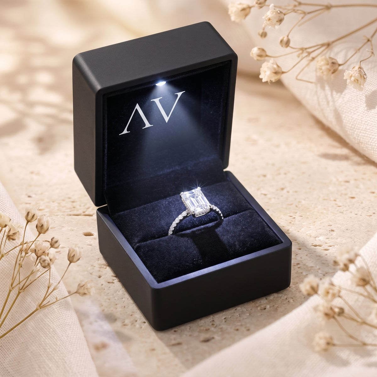 Sterling silver emerald-cut ring presented in a black LED-lighted jewelry gift box.