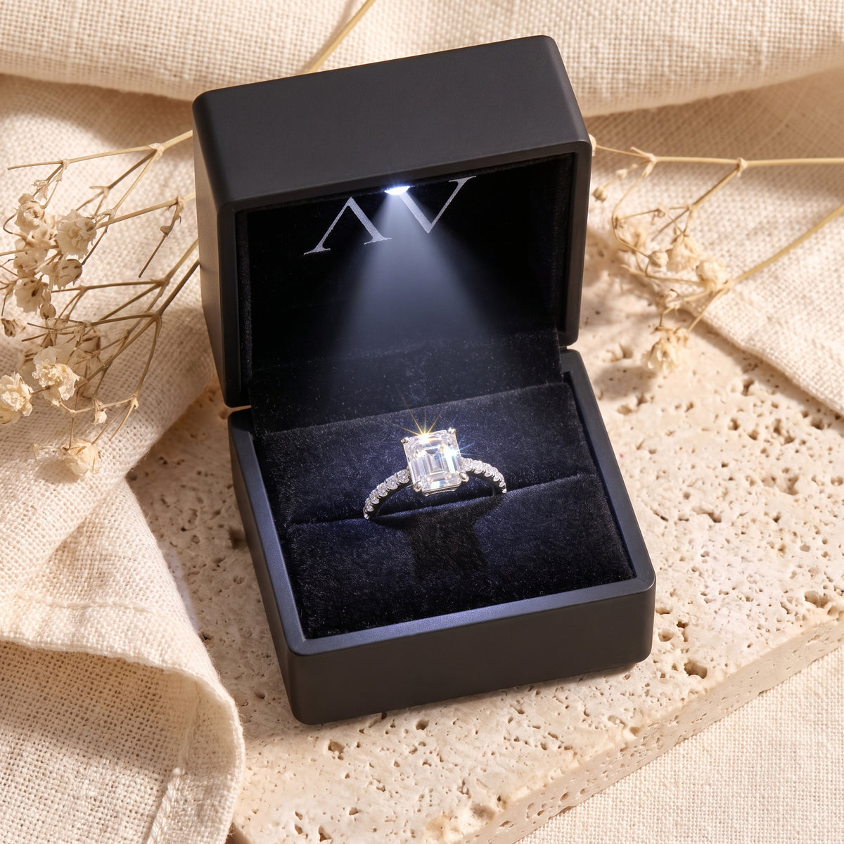 Silver Sarielle East-West ring displayed in a black LED-lit jewelry box on a stone surface.