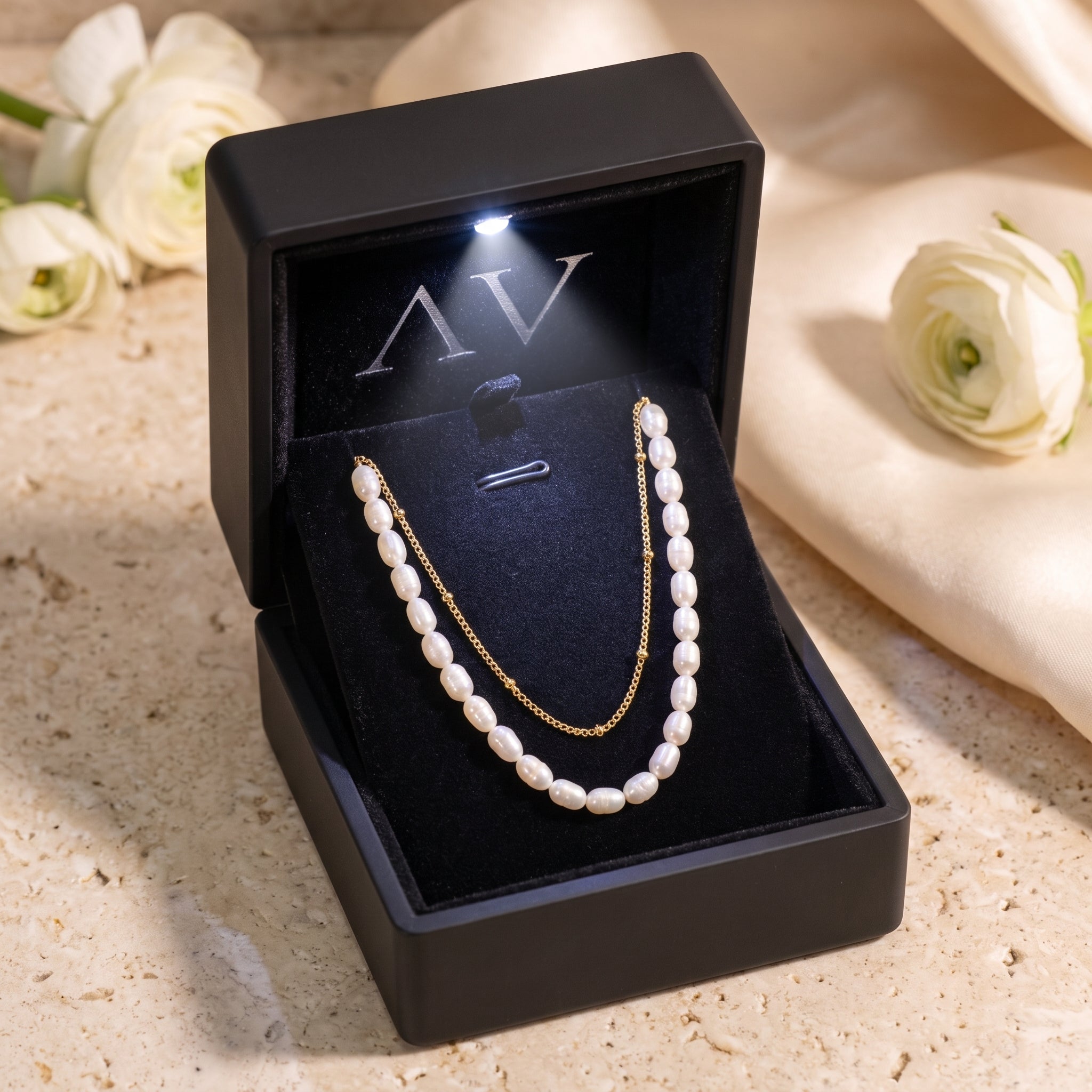 Layered gold and pearl necklace in a premium black LED-lit jewelry gift box.