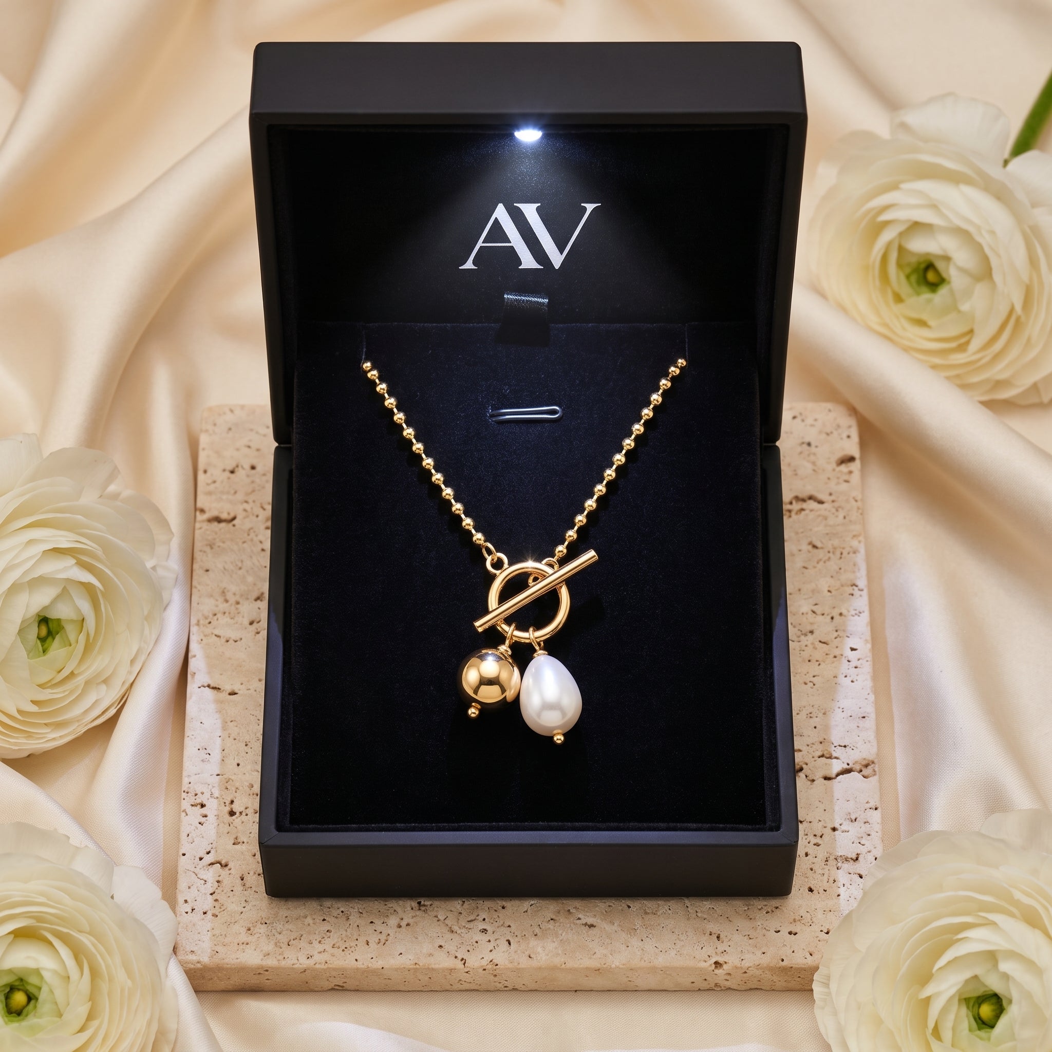 Gold pearl toggle necklace inside a premium black branded jewelry gift box.