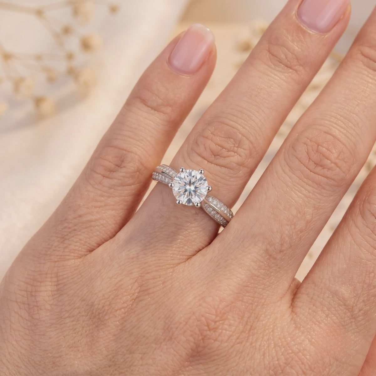 Round clear stone ring with a split-shank pavé band shown worn on a hand.
