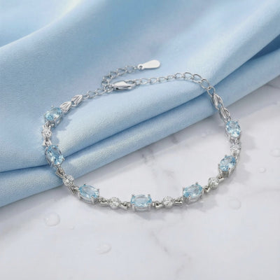 Melodia station bracelet with simulated aquamarine stones in solid gold.