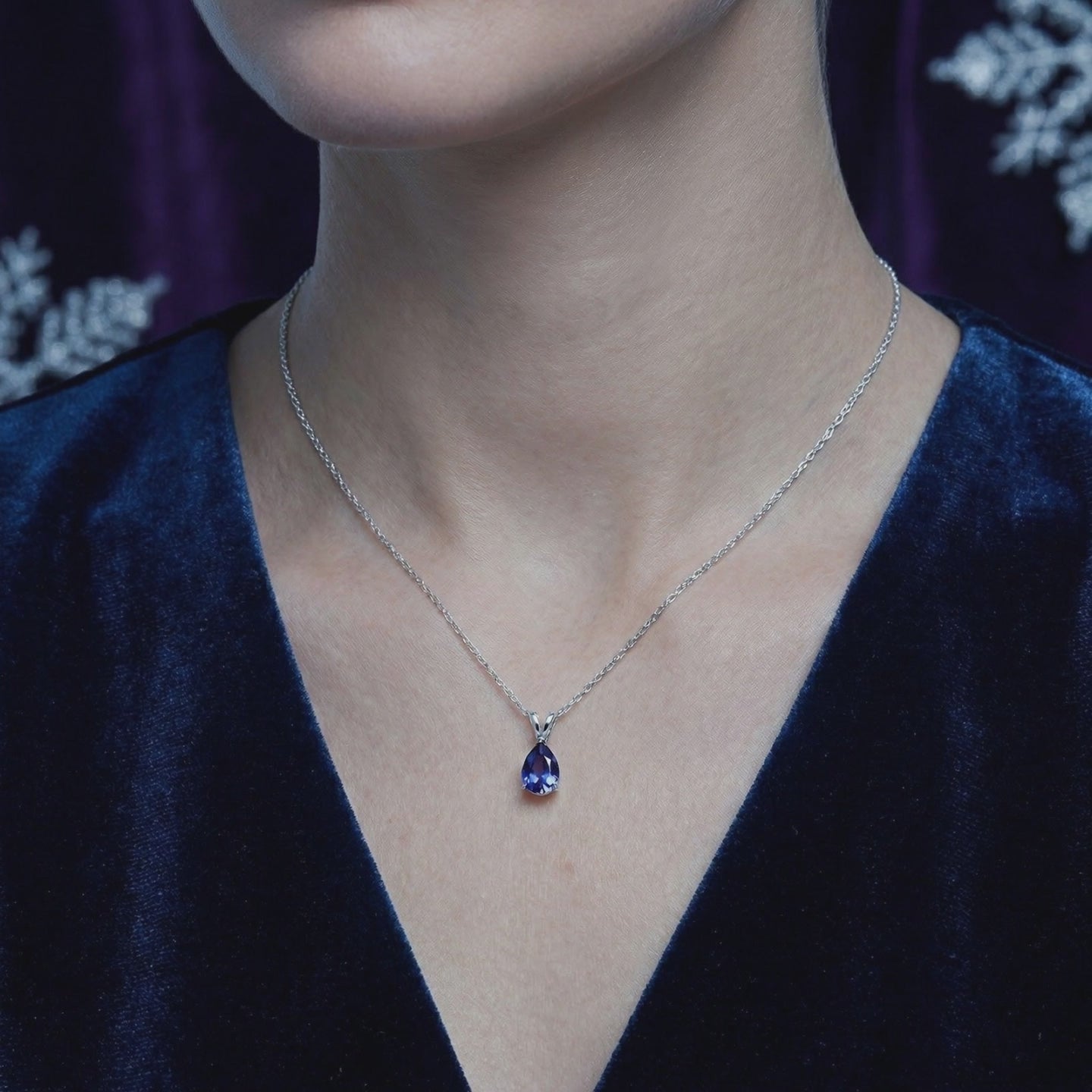 The Calystine Pear solid gold necklace with a pear-cut blue moissanite pendant.