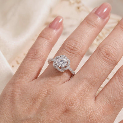 Silver Rosette Swirl Halo ring with a round center stone and pavé accents, shown worn on a hand.