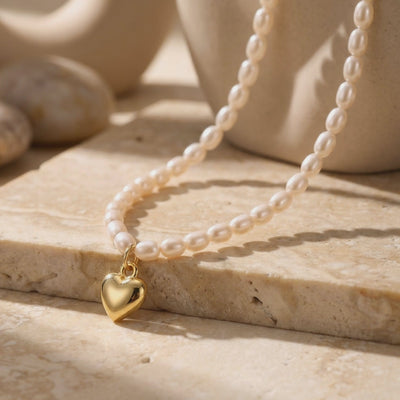 Video of a solid yellow gold heart pendant necklace with synthetic pearls.