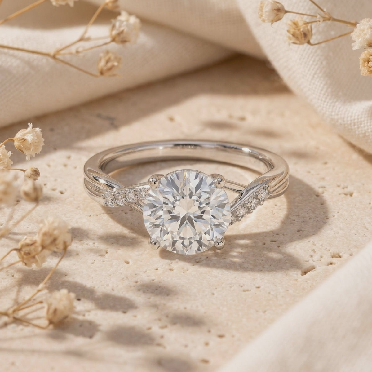 Close-up view of the round moissanite ring with a twisted accent band resting on textured stone with dried flowers.