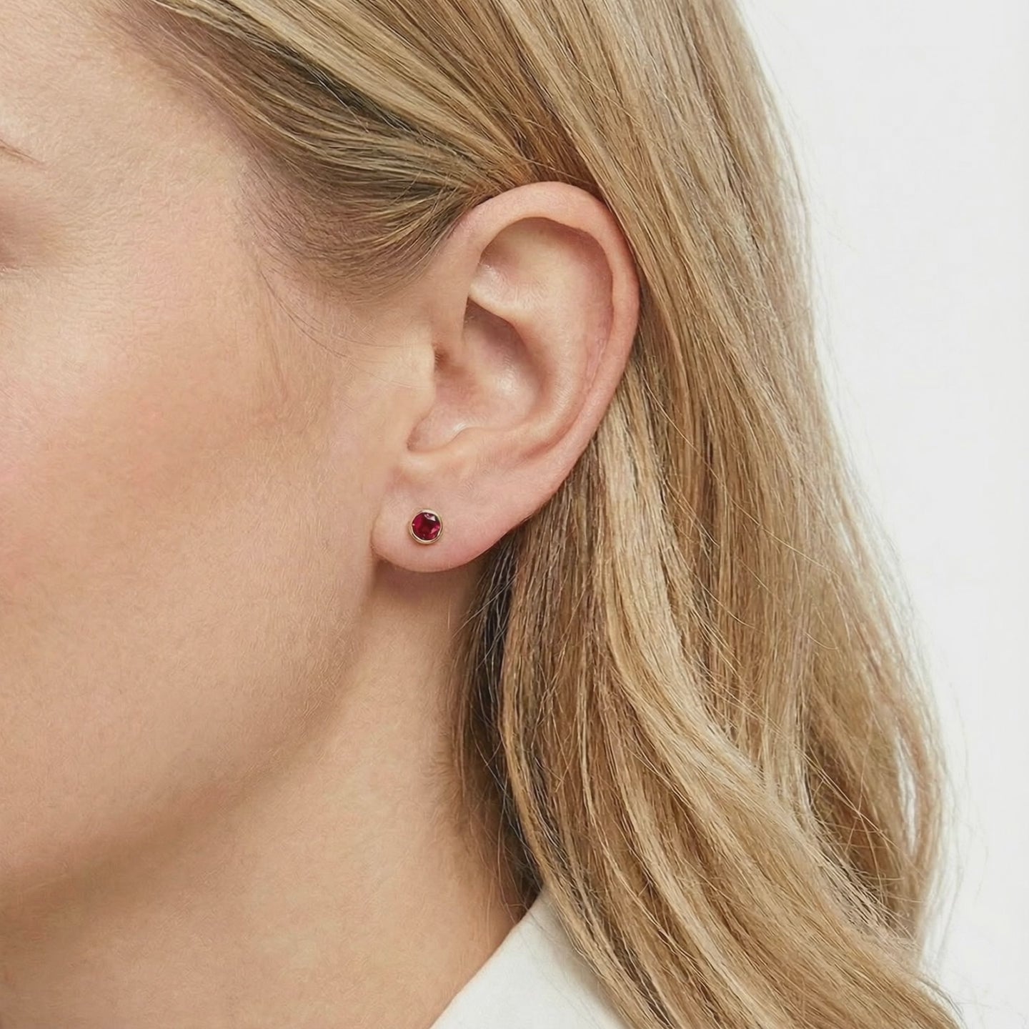 Solid gold stud earrings with simulated rubies.