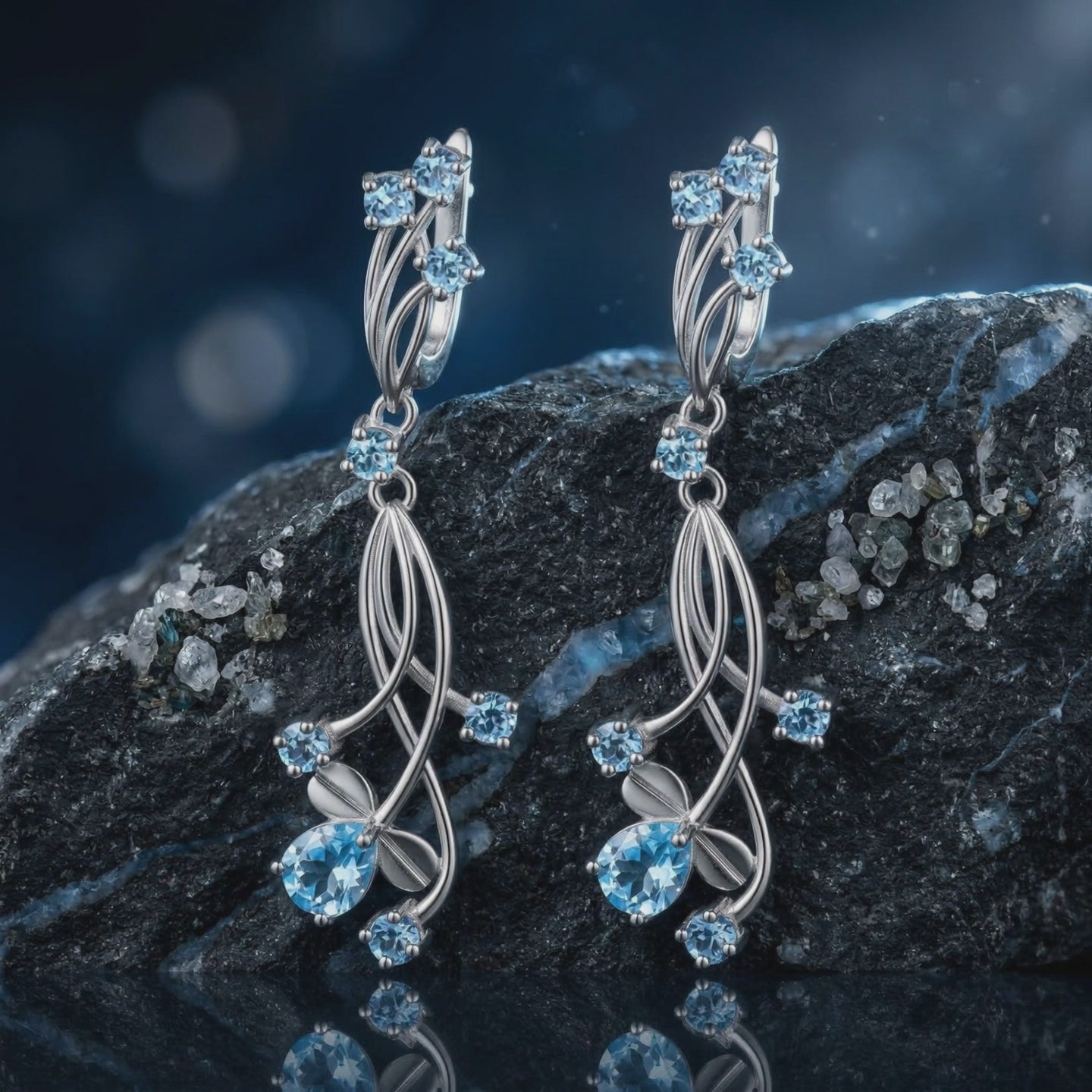 A pair of solid gold earrings with natural blue topaz gemstones.